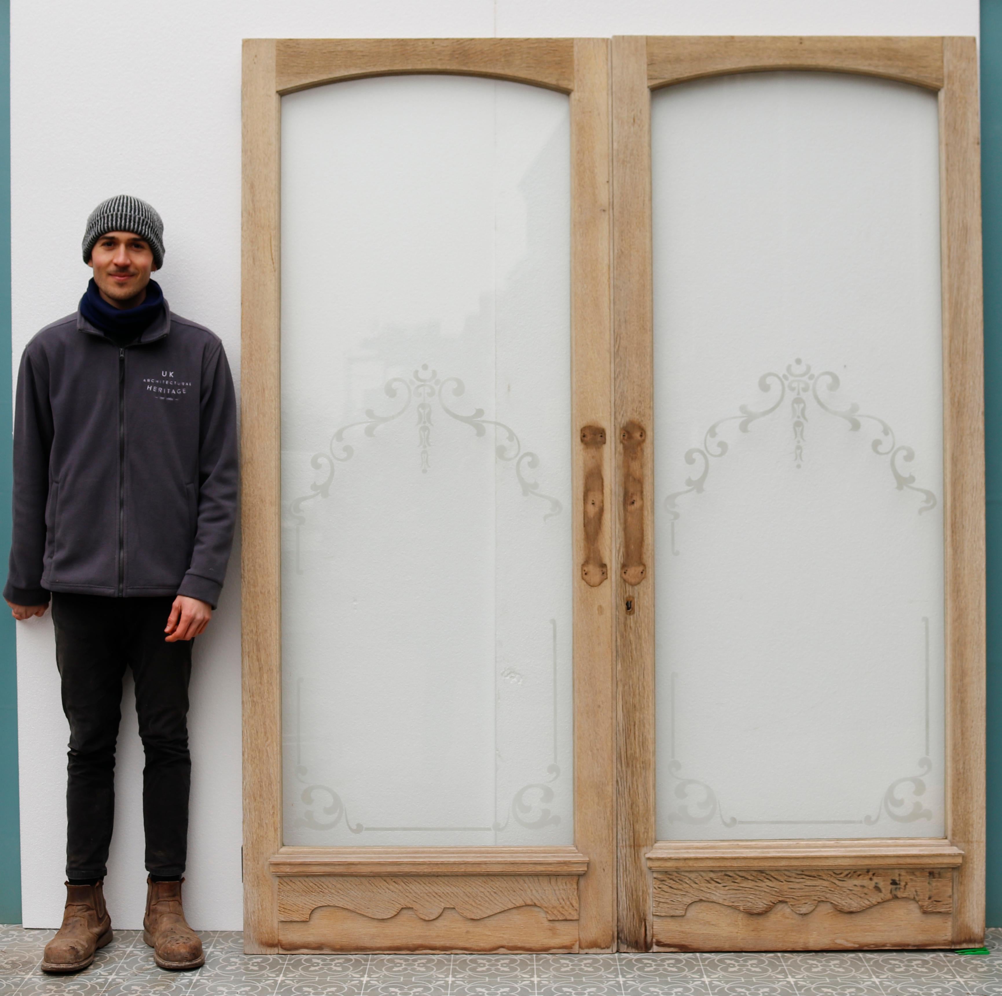 Une impressionnante paire de portes en chêne recyclé avec des panneaux en verre gravé.