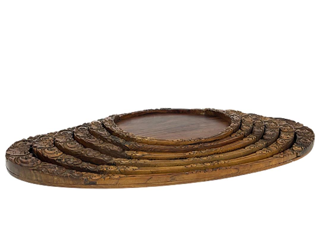 A set of Indonesian teak wooden serving trays. 

6 pieces oval teak wooden serving trays with hand-carved floral motif. All 6 serving trays fit together and make the set complete. 

The size increases from 25.7 cm to 60.5 cm wide and from 20.7