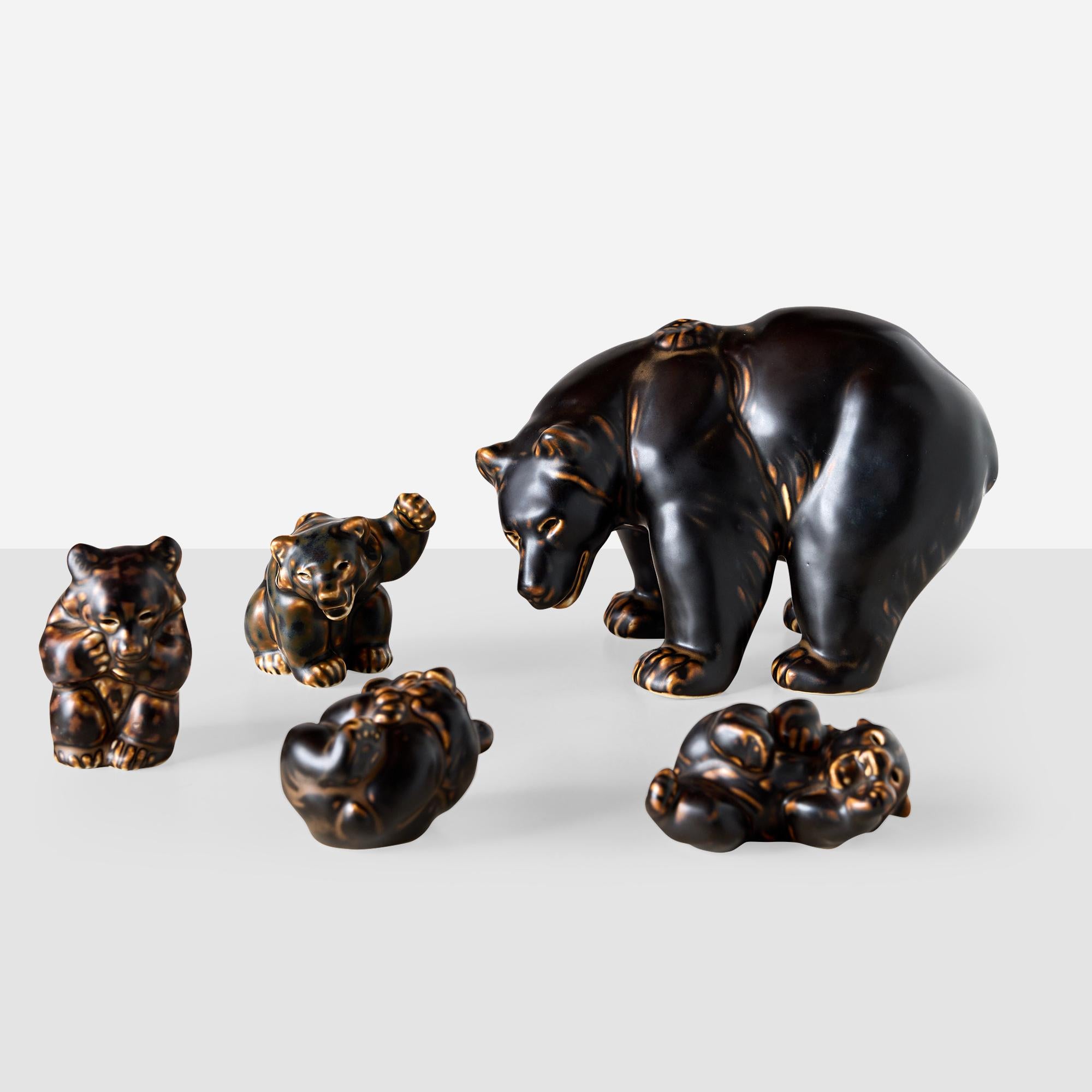 Un affascinante set di 5 statuette di orso in ceramica è stato disegnato da Knud Kyhn per Royal Copenhagen nel 1957, mostrando la sua maestria nel raffigurare animali giocosi e realistici. Questa collezione comprende un padre orso in piedi e quattro