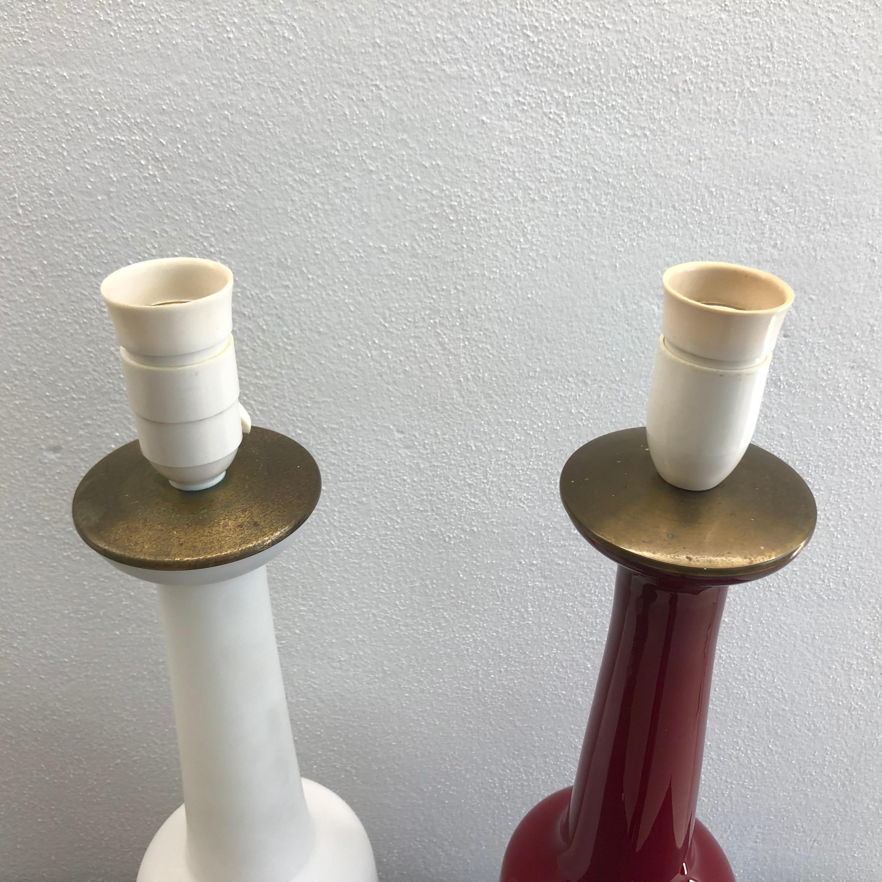 The lamps was designed by Bent Nordsted in 1958 and manufactured by Fyens Glasswork, then a part of Holmegaard Glasswork for Bent Nordsteds firm Nordsted & Co.

One is in mouth blown shinny red opal glass and the other is in Matt white opal