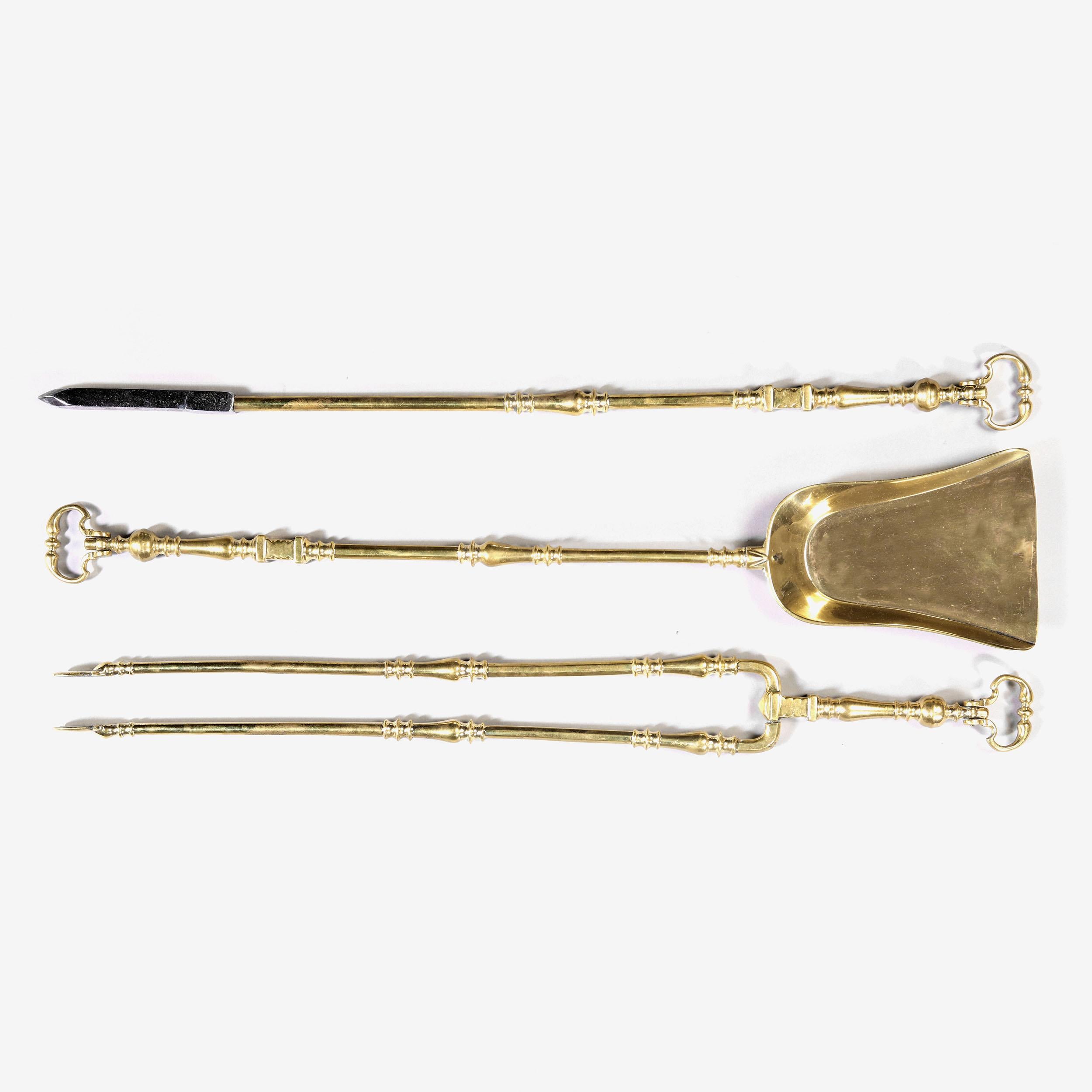 A good scale set of three brass and steel fire tools with moulded shafts.