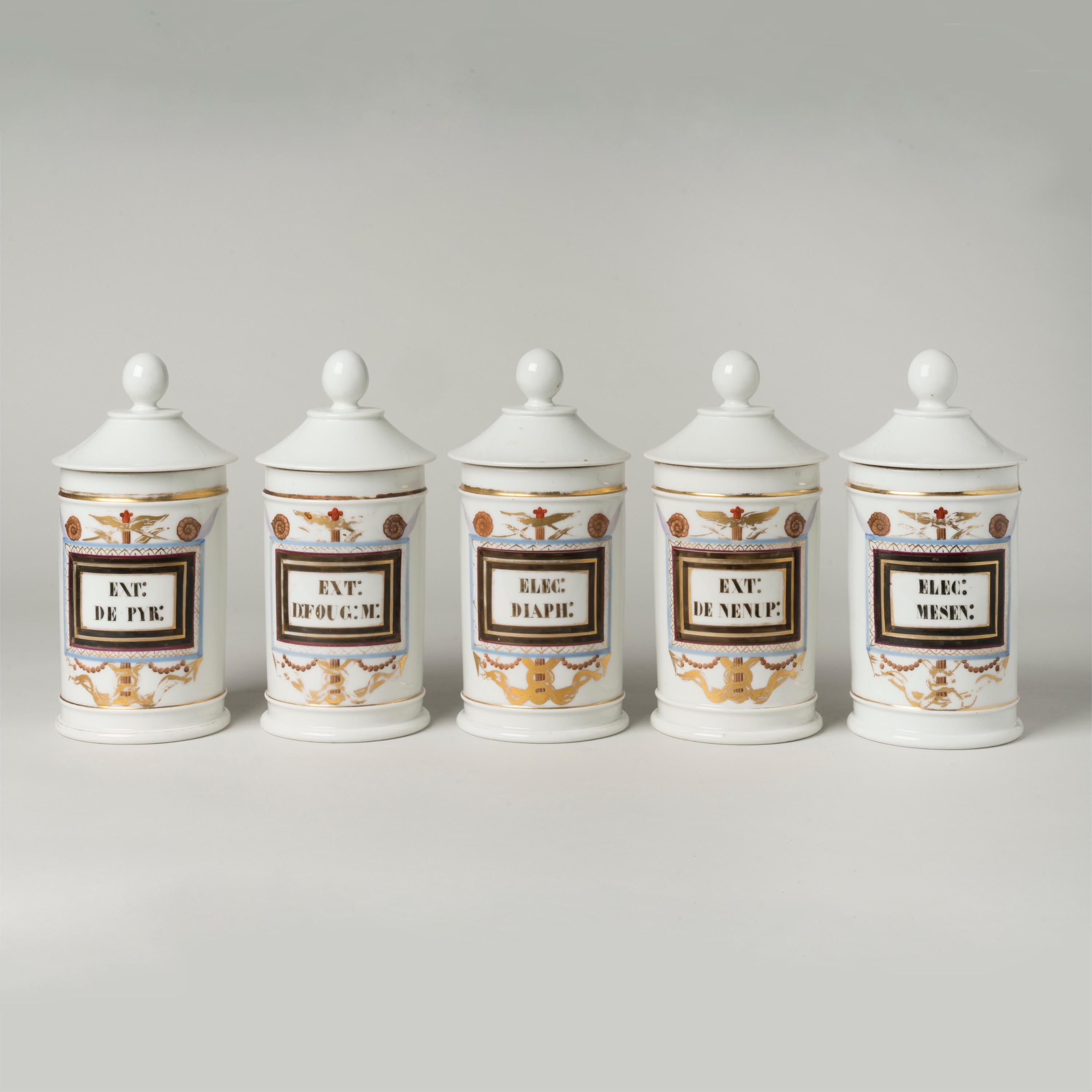 Juego de cinco tapas de porcelana de París
Tarros de boticario

Cada uno de los frascos de porcelana tiene una tapa en forma de cono con un remate en forma de bola; la parte frontal de los frascos está decorada con motivos policromos y dorados, así