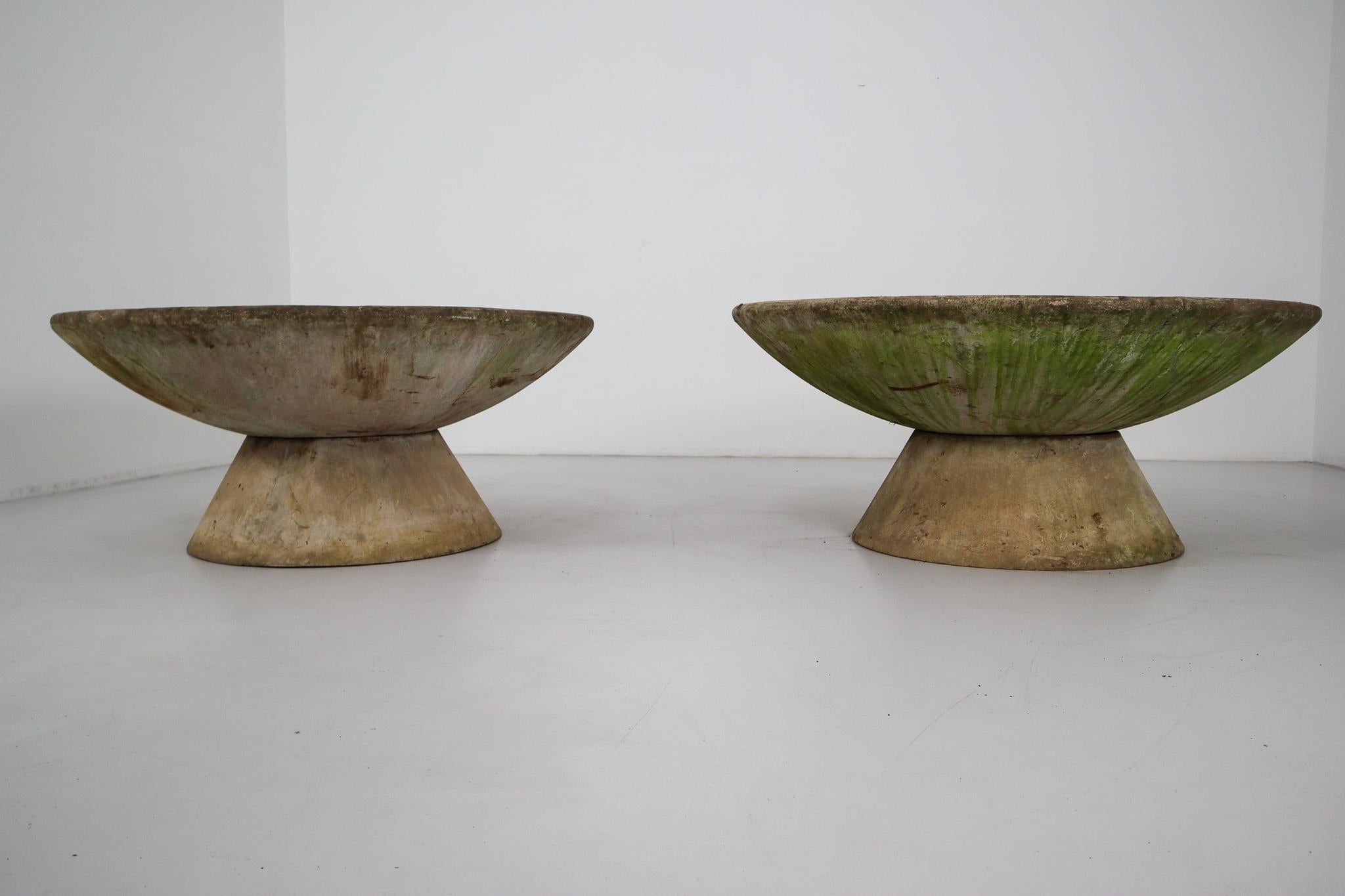 A fine pair of very large Mid-Century Modern large saucer planters of composition stone for an indoor or outdoor garden, garden room, or terrace. Each large round or circular discus resting on a smaller raised support.