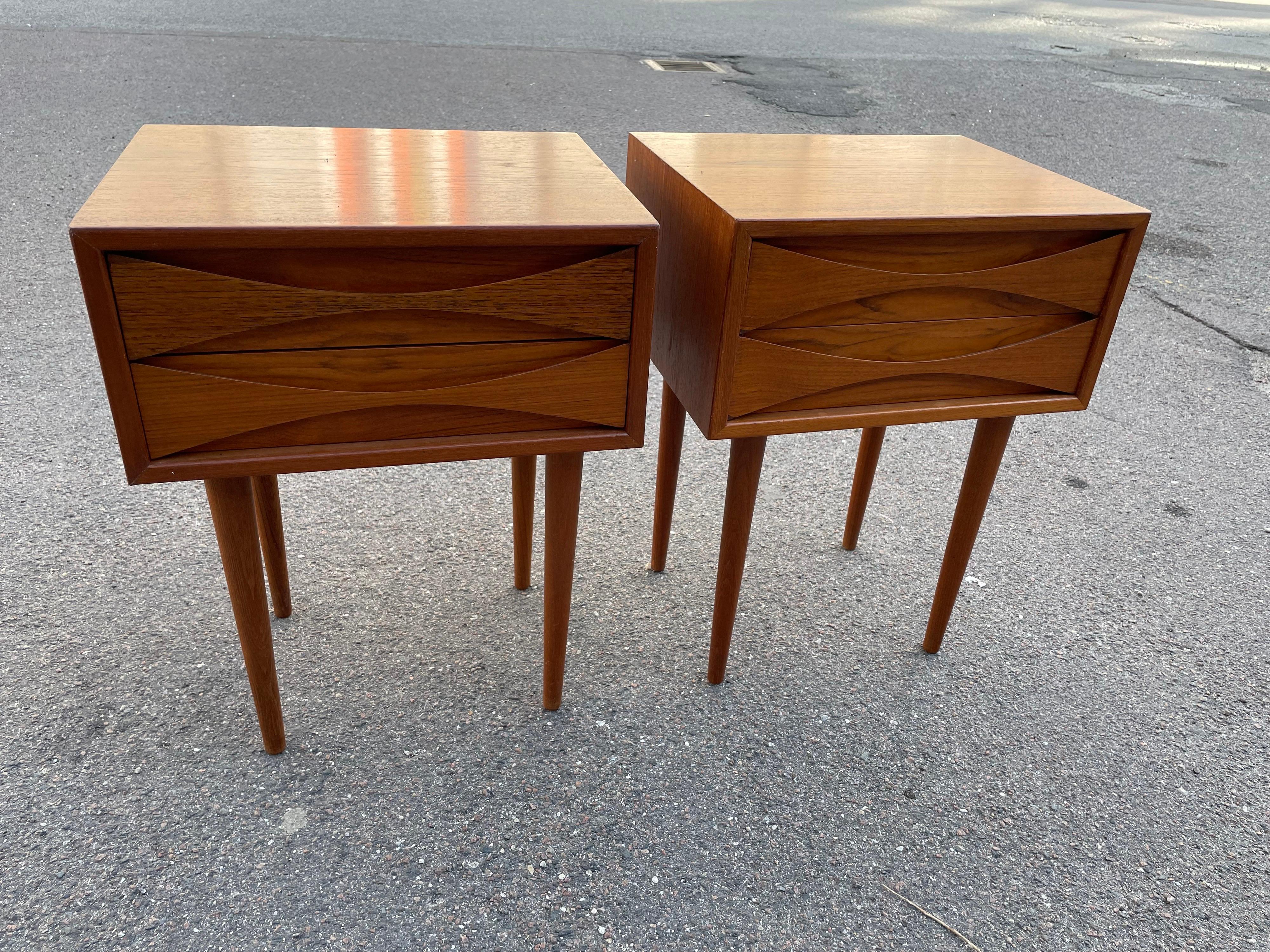 Mid Century-Modern teak cabinets by Niels Clausen for NC Mobler, Odense, Denmark. Produced c1960. Two drawers per cabinet with scalloped pulls and solid tapered legs.