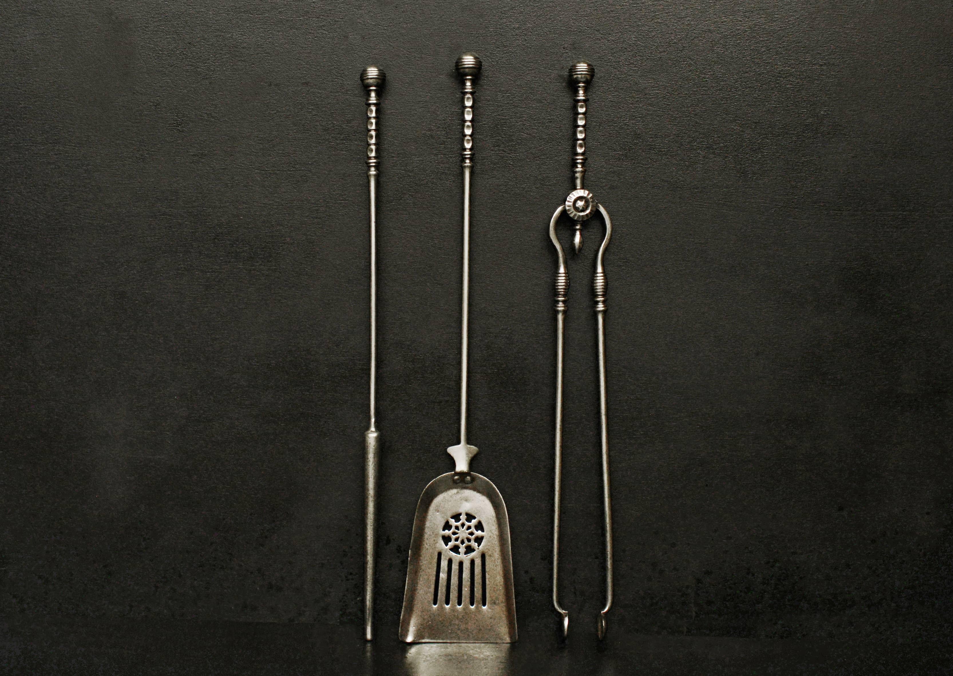 A set of polished steel firetools in the Georgian manner. The pierced pan with fluting and rosette, the handles with ball finials. 19th century,

Measures: Length: 715 mm 28 ?