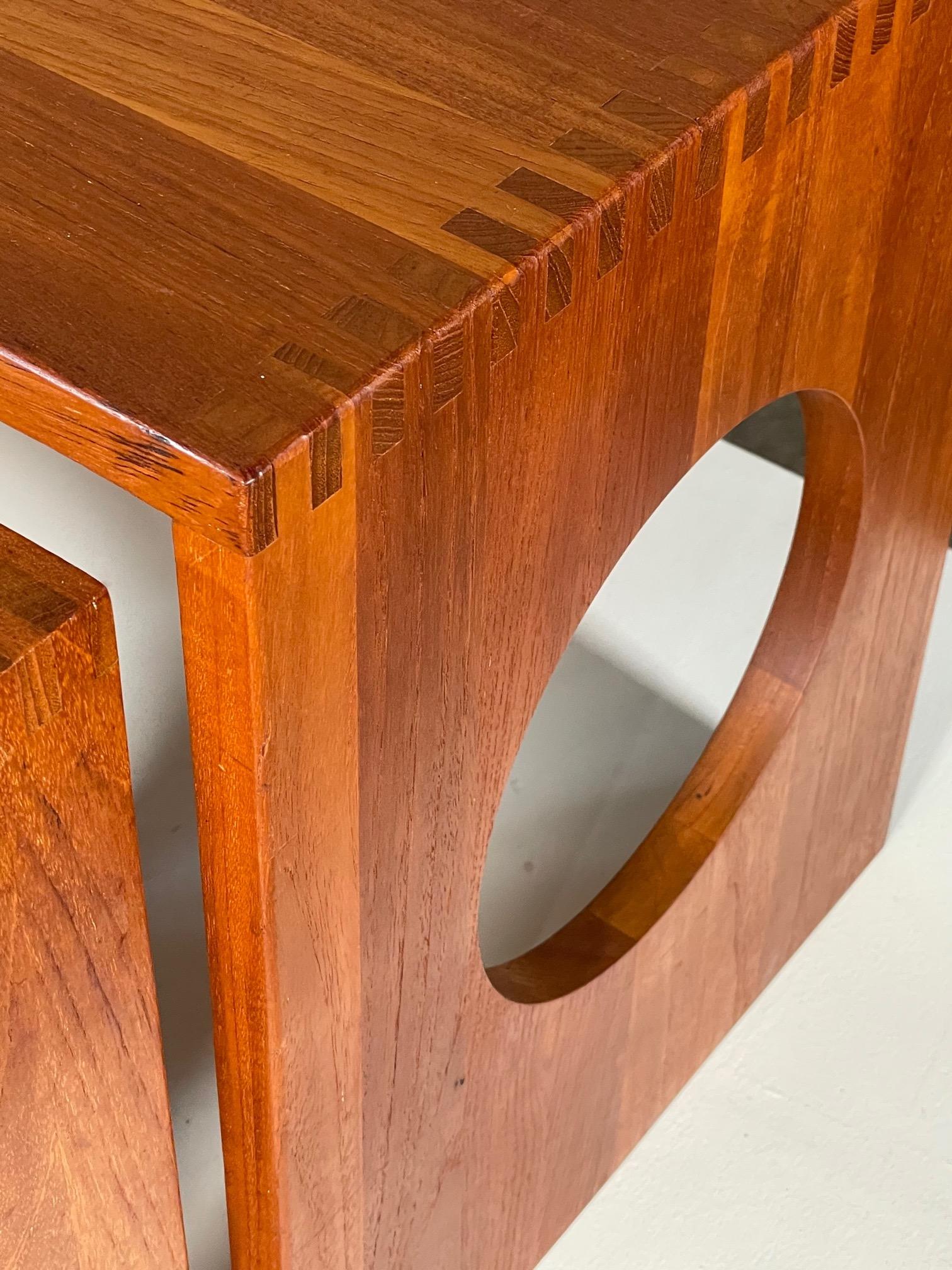 A set of three classic nesting tables designed by Jens Quistgaard, produced by Richard Nissen, Denmark, ca' 1970's. Made of teak with characteristic finger joints and circular cut outs. can be used as side tables or nesting tables, etc.. The