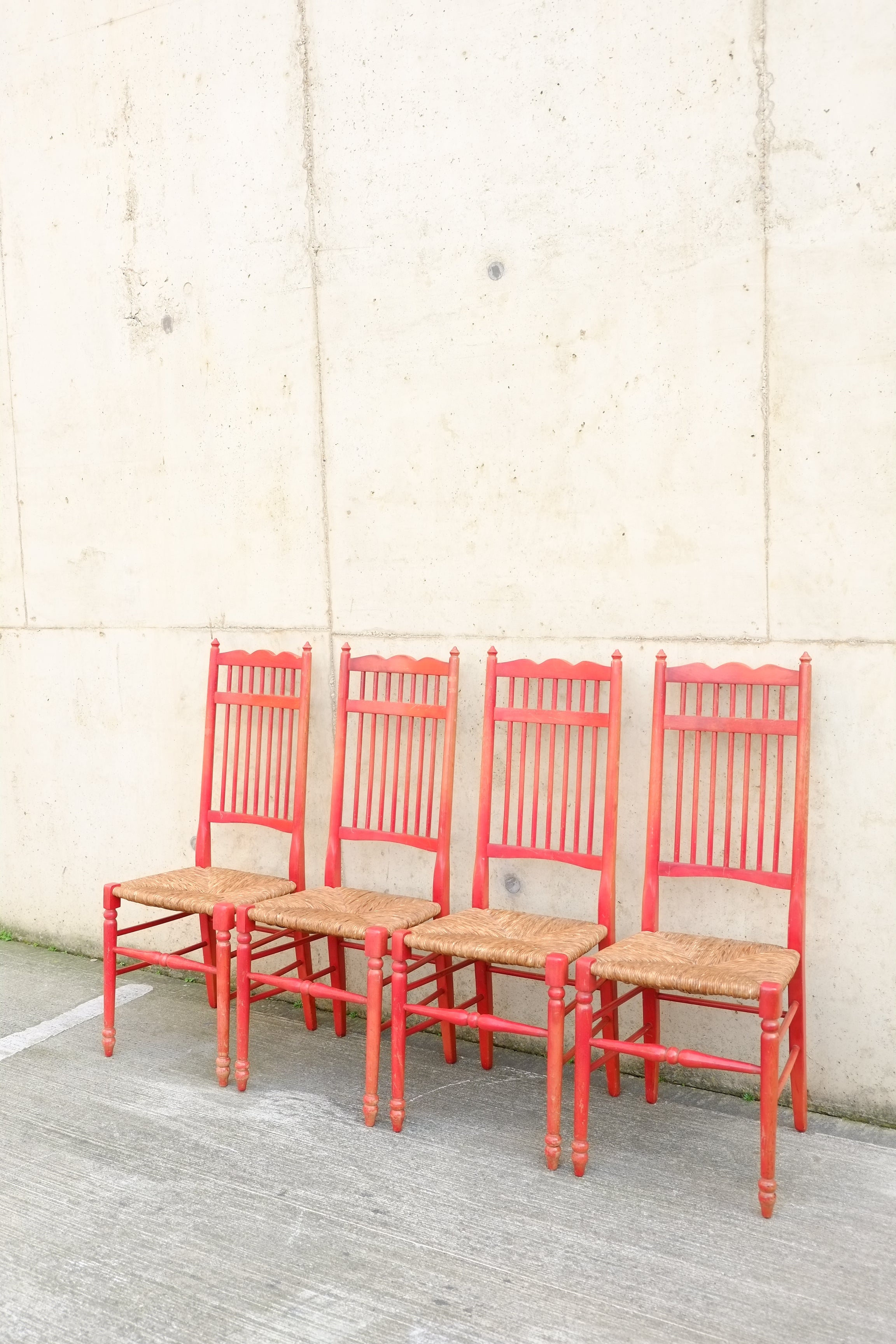 Un set di quattro rare sedie con schienale a fuso in una bellissima lacca rosso fragola. Le sedie hanno una forma raffinata ed elegante, con un alto schienale a fuso e terminali torniti. Queste sedie sono state progettate e realizzate con un'elevata