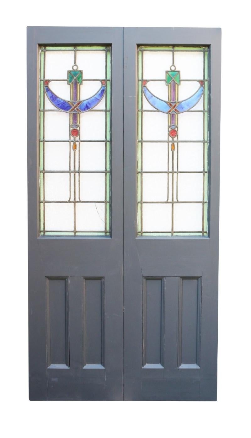 A set of painted exterior doors with stained glass panels.