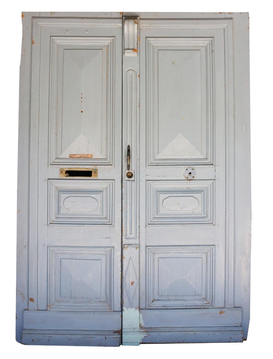 A set of reclaimed doors with shaped raised panels, painted in light blue.