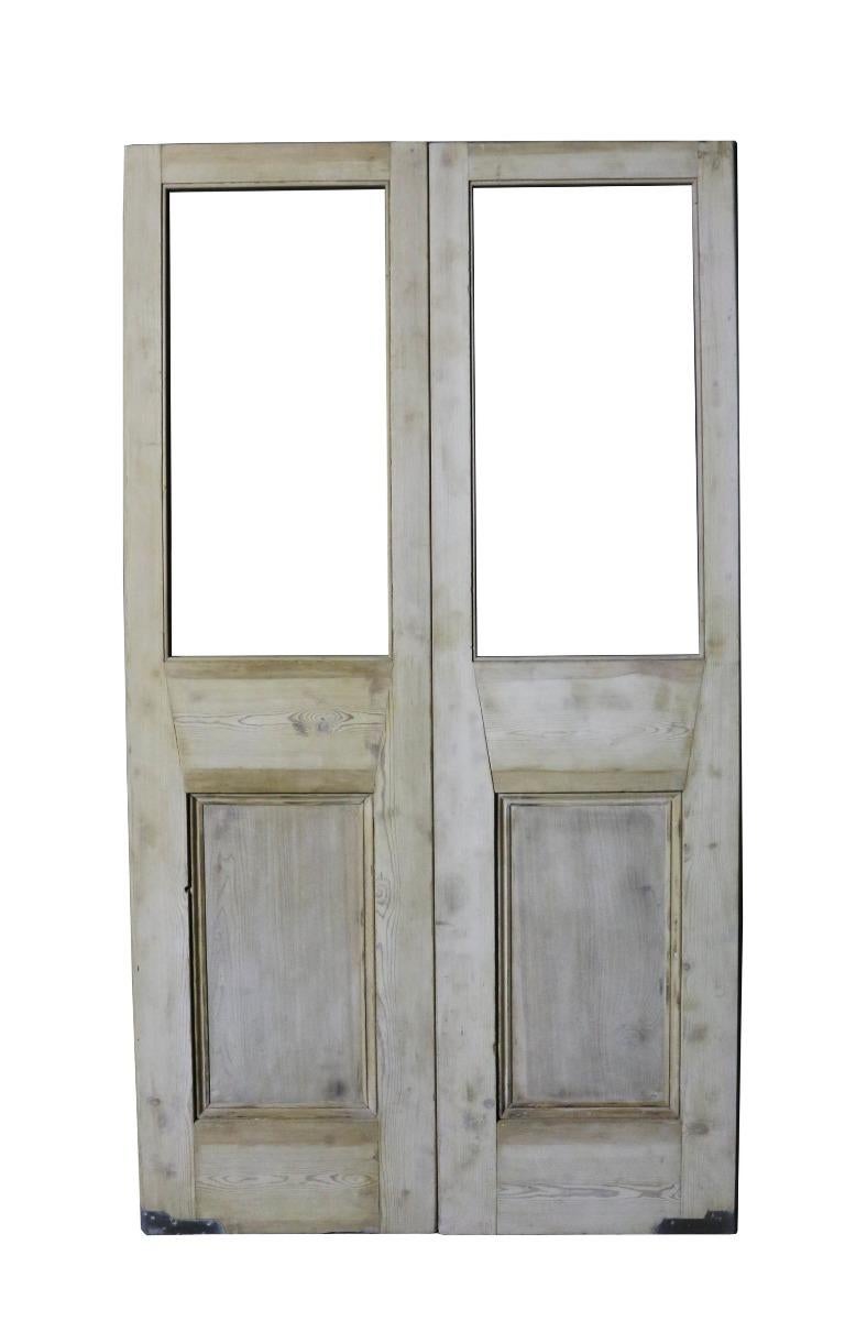 A set of antique double doors with two panes for glazing.