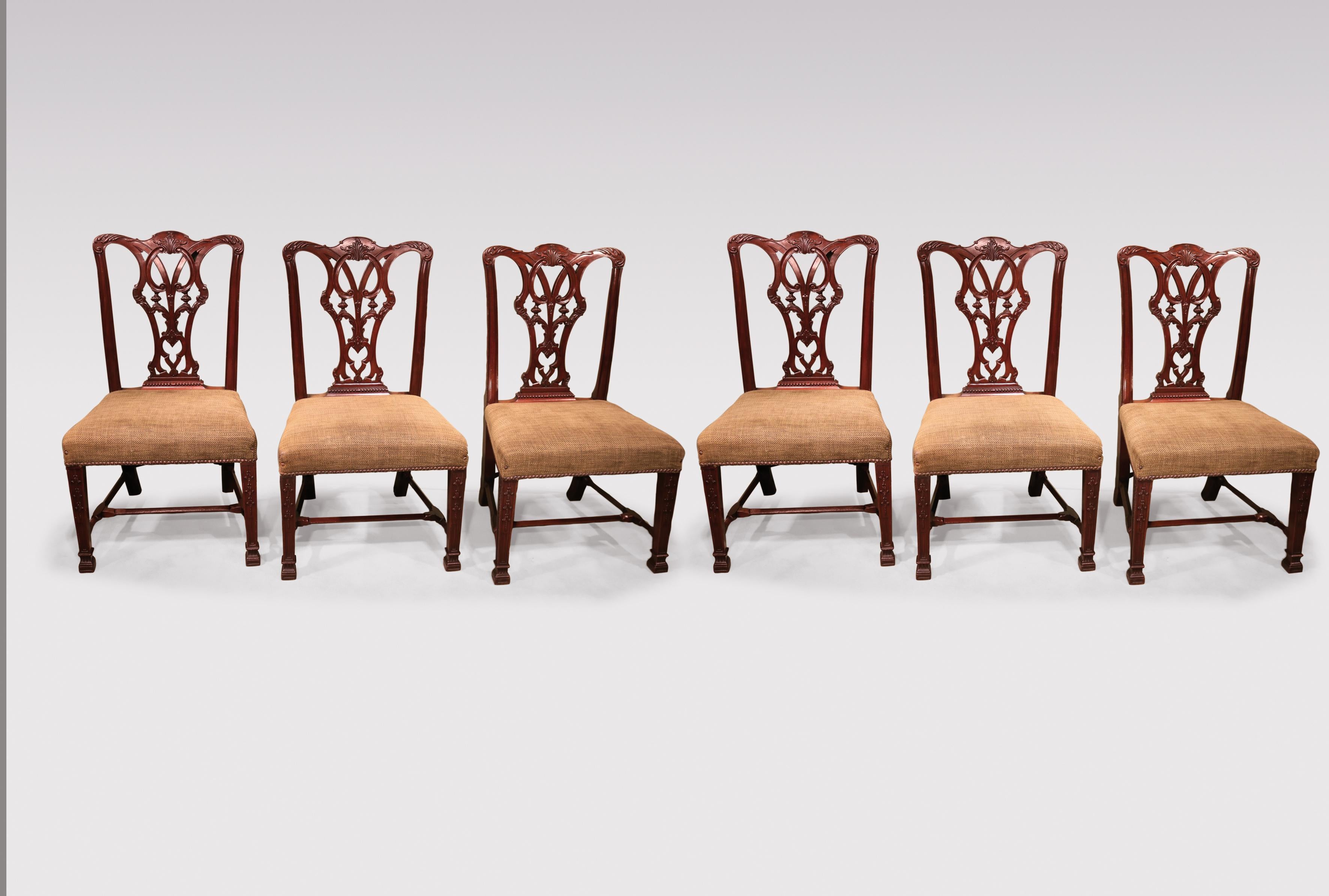 A set of 6 19th Century Chippendale style mahogany dining chairs having acanthus carved top-rails above pierced scrolled splats with vase & gadrooned detail, supported on square tapering legs with inset panels carved with harebell decoration, joined