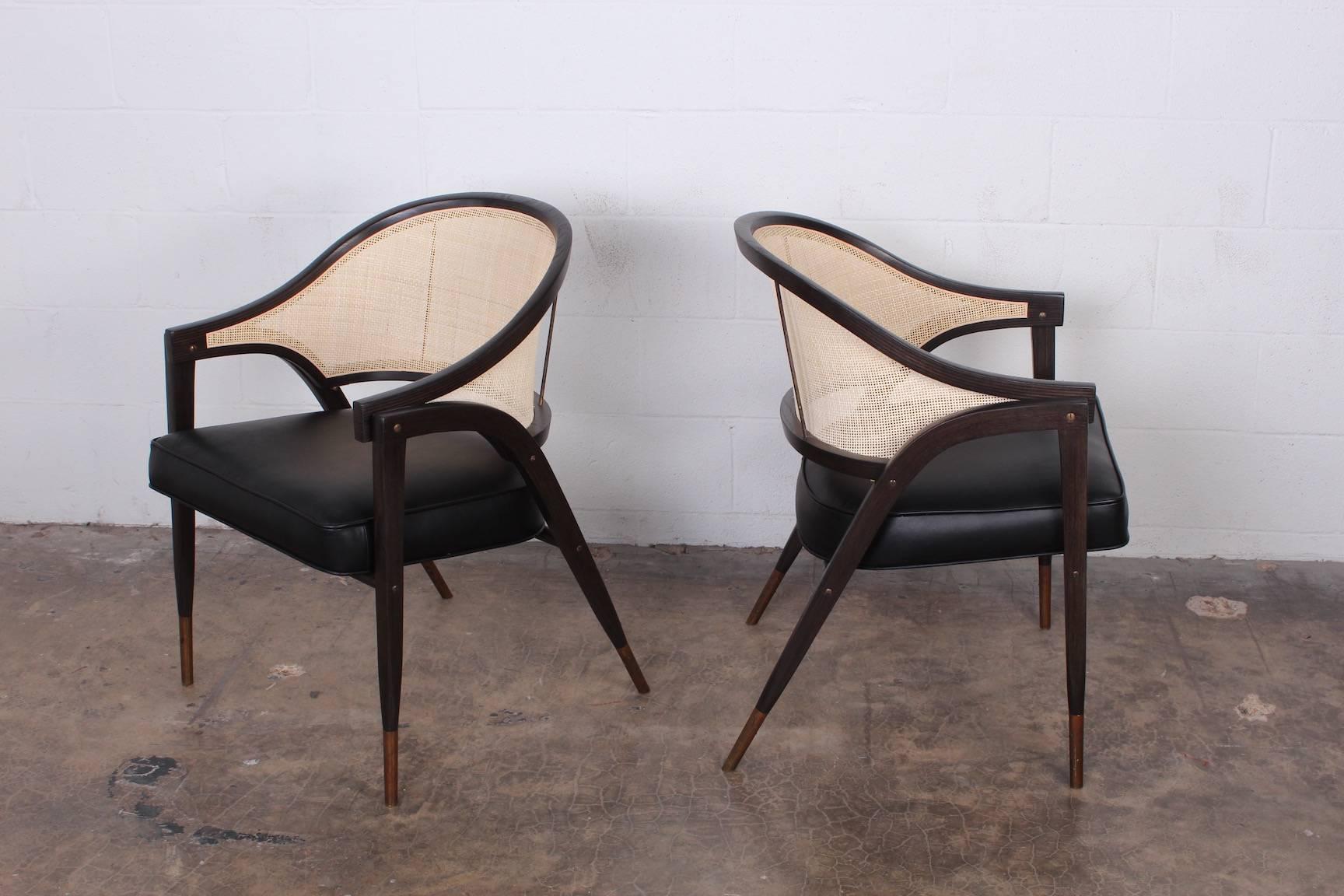 A set of six cane back armchairs with brass sabots and leather upholstery. Designed by Edward Wormley for Dunbar. Fully restored. Priced and sold in pairs.