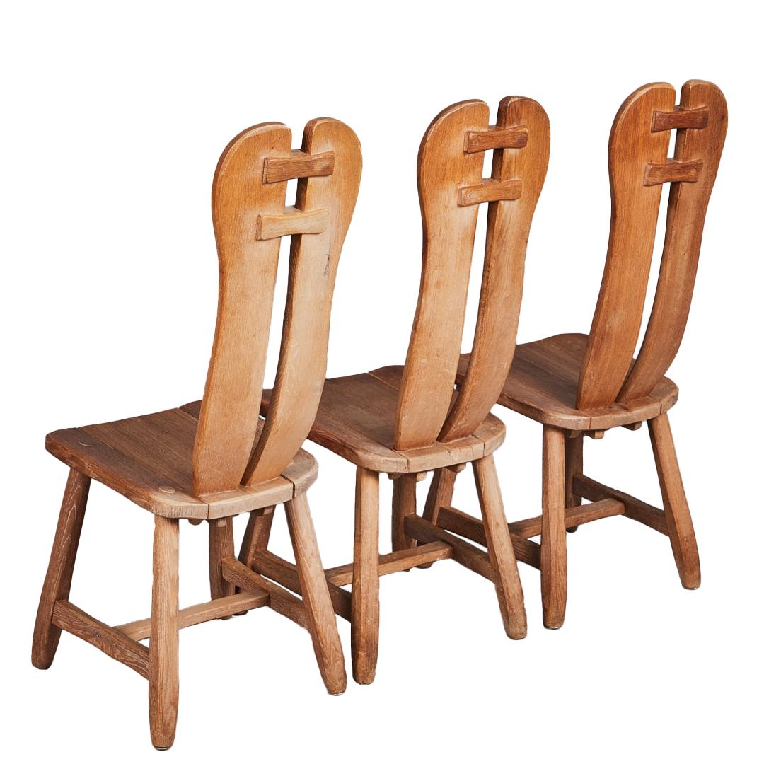 Un set di sei sedie da pranzo in rovere bianco patinato in stile brutalista del produttore belga De Puydt. Gli alti schienali a sbalzo in legno listellare sono uniti da mortase e tenoni a forma di arco. Il sedile in legno sagomato è sostenuto da