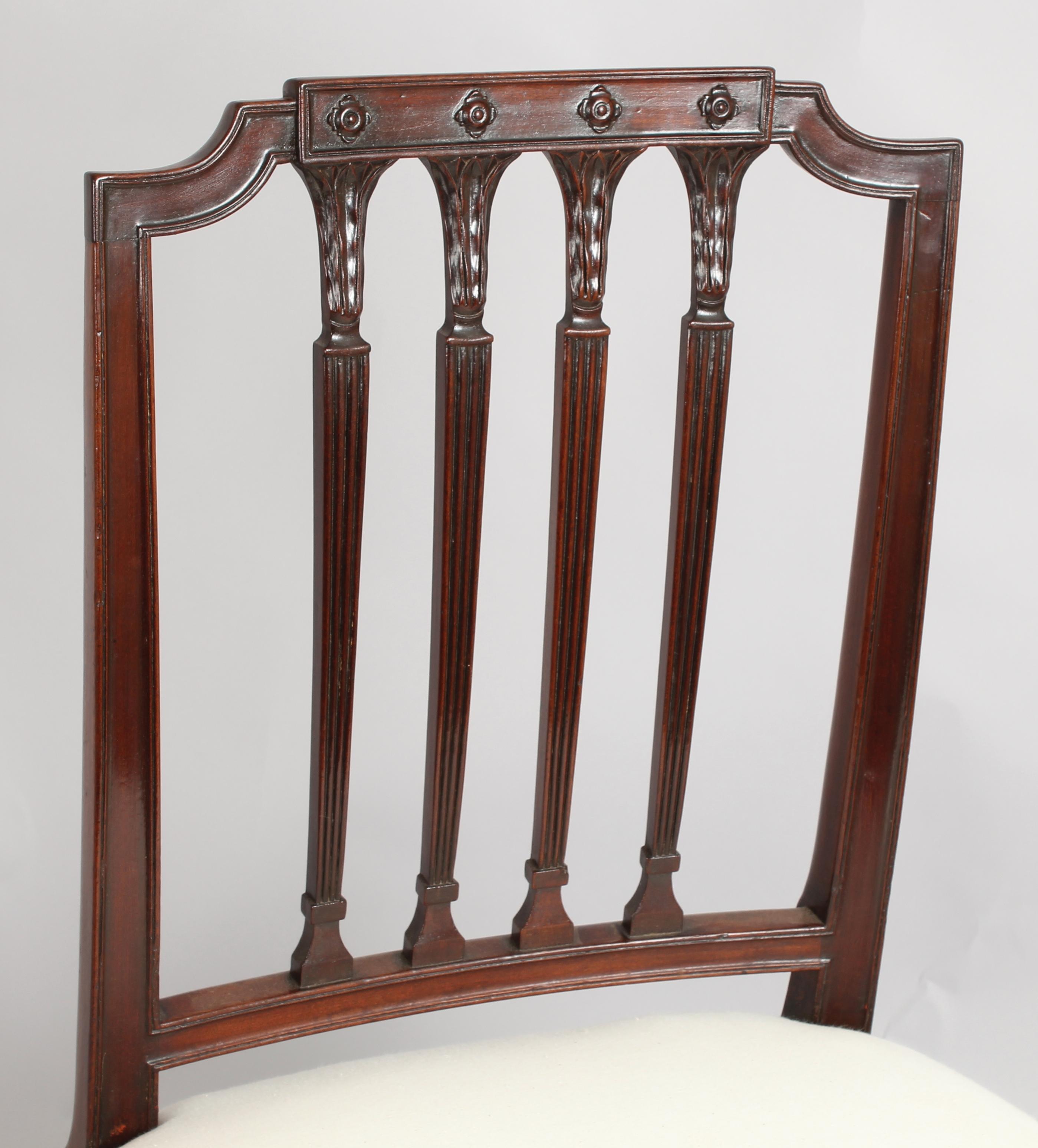 A set of six fine George III period mahogany dining-chairs in the Hepplewhite style; the backs with channelled frames, a central tablet with carved florets and four reeded splats with water-leaf headings: the stuffover seats re-upholstered and
