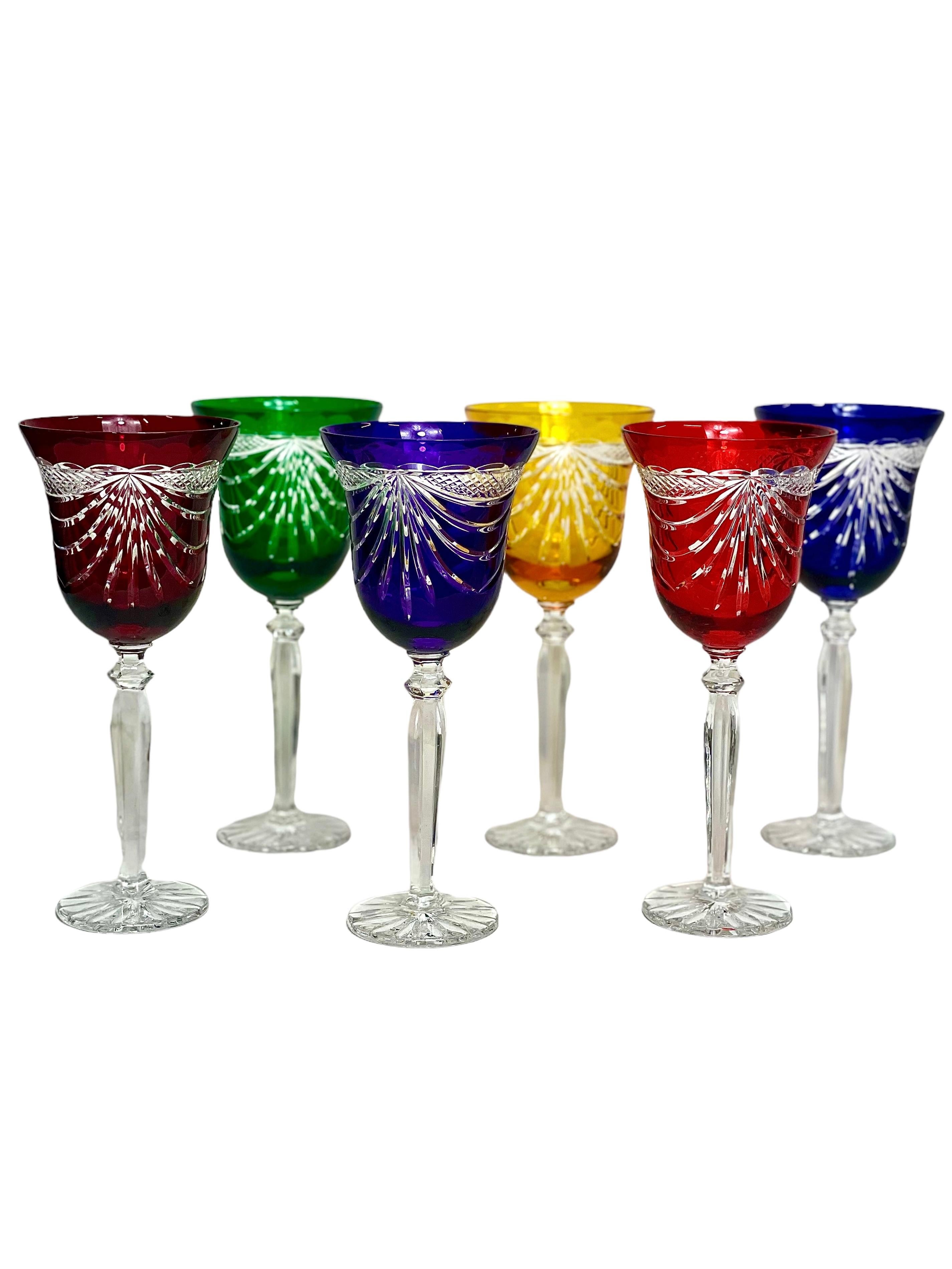 A fabulous set of six crystal Rhine (or white) wine glasses, in a rainbow of colours, and richly cut with an exquisite swag motif. These glittering glasses are an unusual shape, with a cupped bowl, tall stem and flat, round, star-cut pedestal. Each