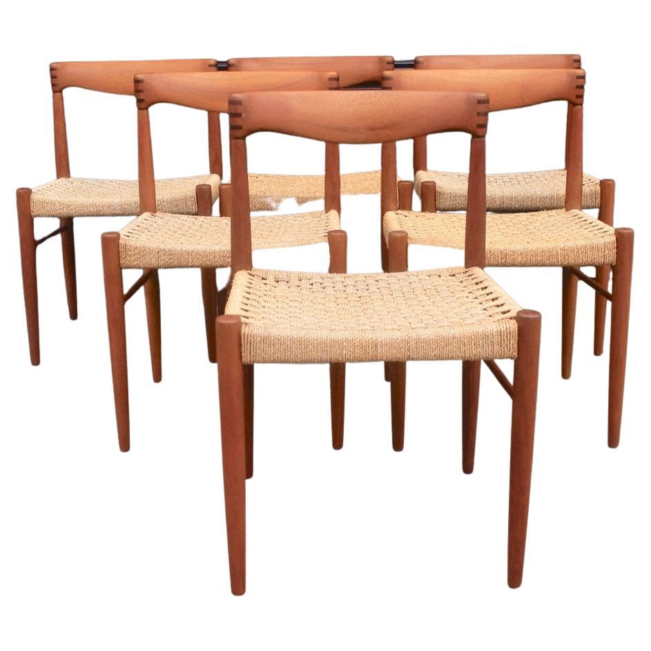 A very nice set of six teak framed dining chairs with hardwood detailing to their backrest and woven rope seating. These vintage 1960s Danish chairs were designed by H. W. Klein and produced by Bramin. Although, the wood on these chairs have been