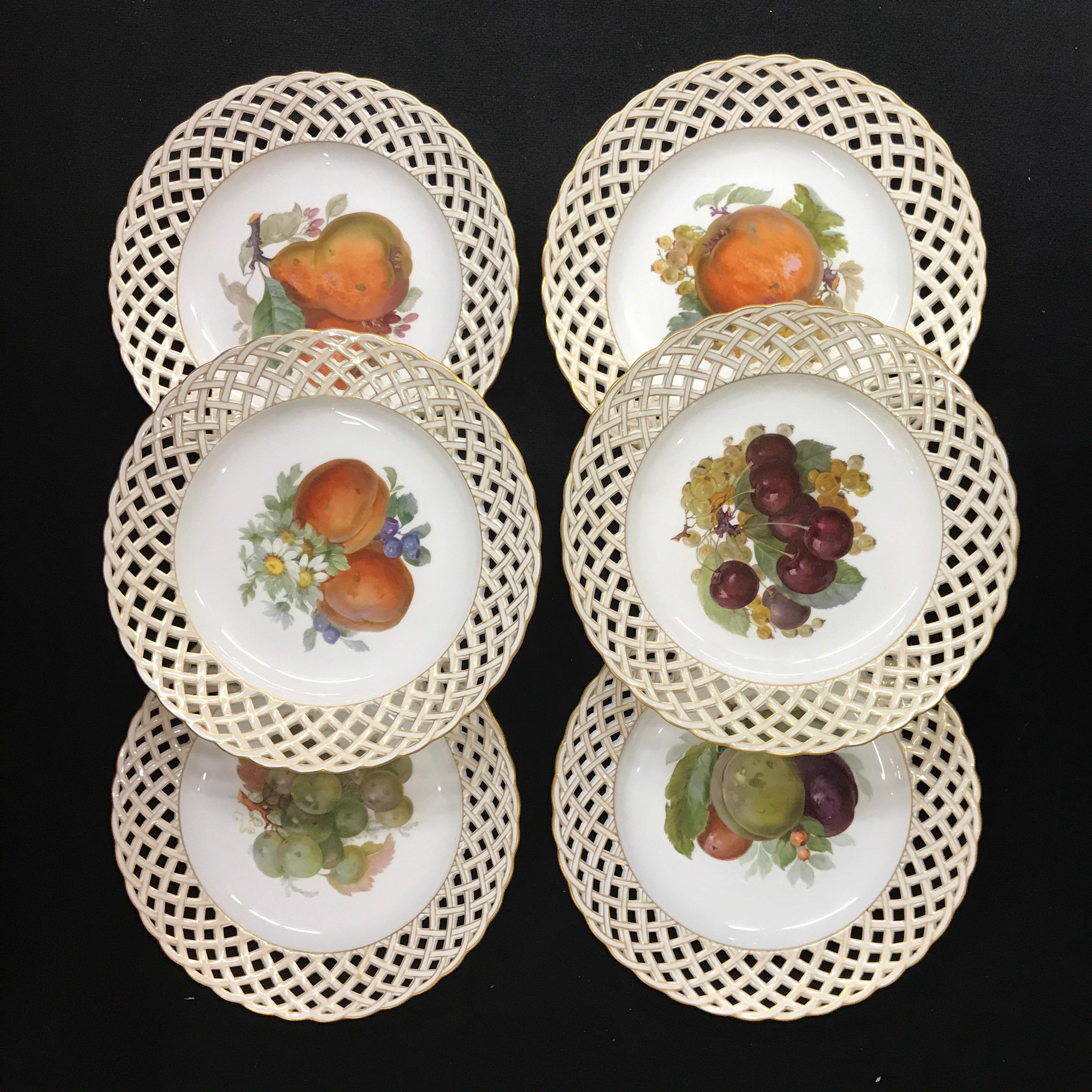 A set of six KPM fruit reticulated plates, each one painted with central lush fruits and flowers, pierced gilt borders, all marked KPM and orb mark, one plates bears the 1763-1913 Anniversary mark.
