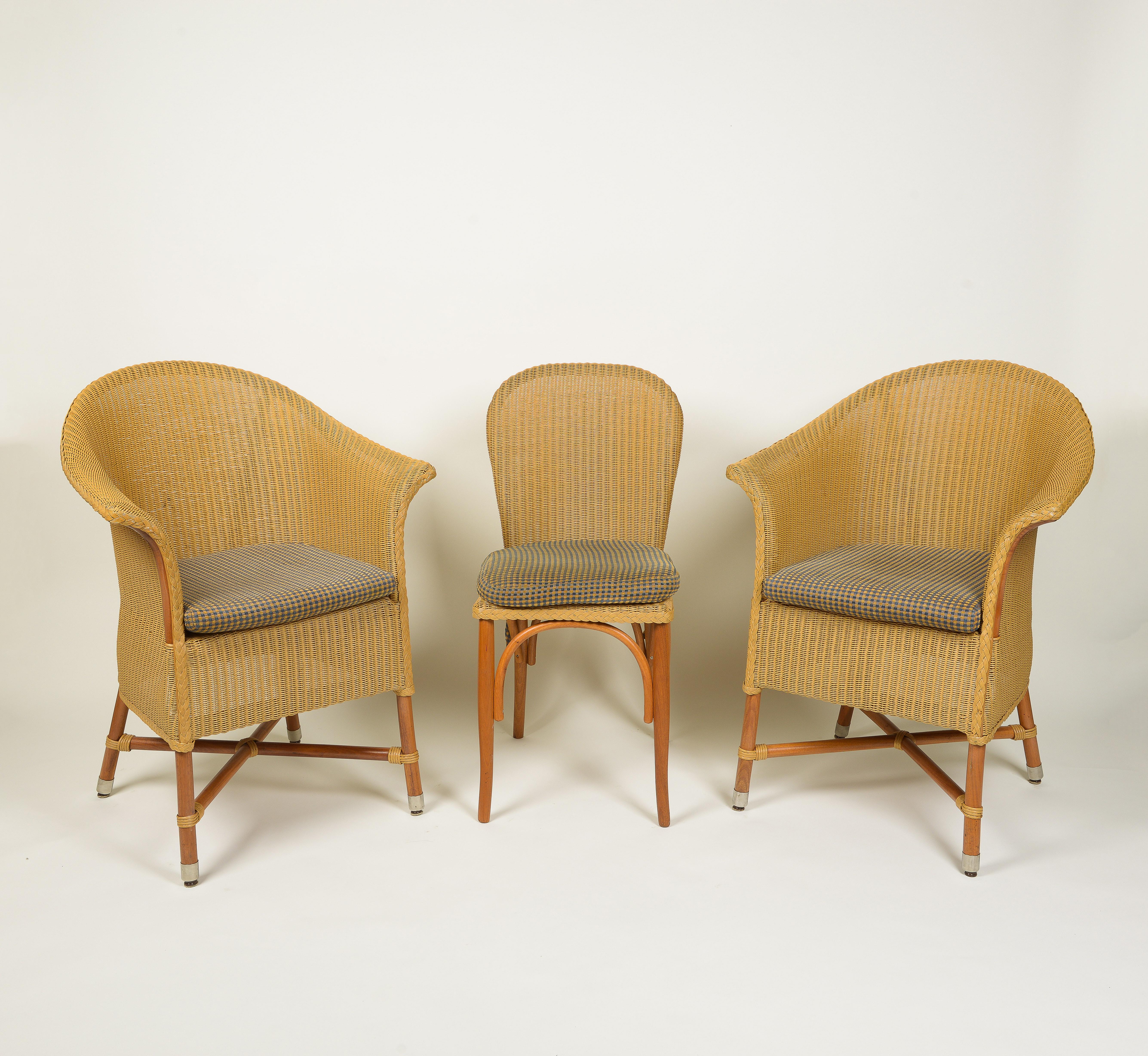 Comprising four armchairs and two side chairs; each with custom blue and brown checked chenille seat cushions; bearing metal label Lloyd Loom Italia.

Dimensions:
Chairs with Arms: Height: 35.25 x Width: 27 x Depth: 22.75 x Seat Height: 18 inches