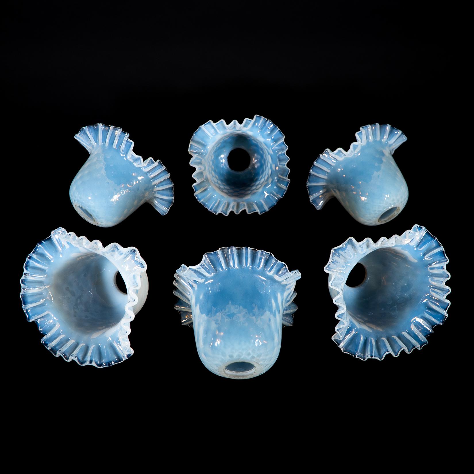 Un set di sei paralumi in vetro di vaselina blu opalescente con design strutturato e bordi delicatamente increspati.
Diametro del foro del paralume: 2,7 cm/1,06