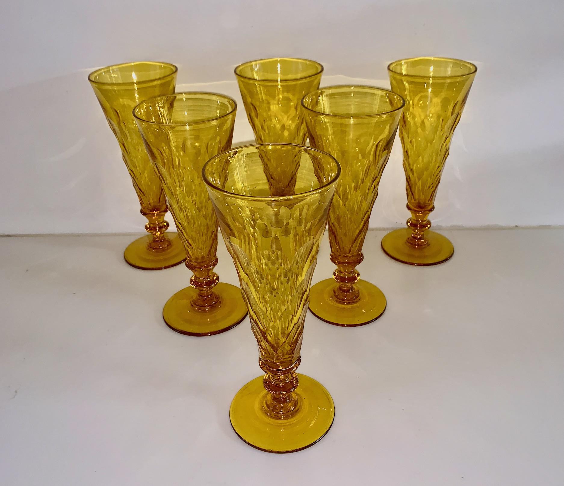 This is a rare and beautiful set of of six champagne flutes in an almost Canary Yellow color and are attributed to the Steuben Glass Company.Steuben Glass was started in England in the early part of the 20th C. and a few years shortly there after