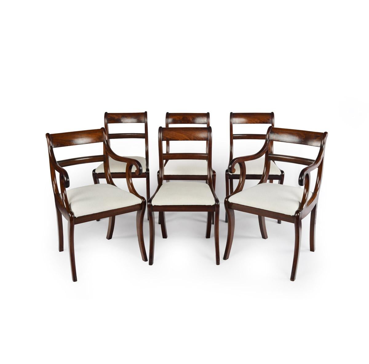 Un set di sei sedie da pranzo Regency in mogano con gambe a sciabola, composto da due poltroncine e quattro sedie laterali, ciascuna con seduta a ribalta, le poltroncine con braccioli a C, inglese, circa 1815.

Altezza 34 pollici Larghezza 20 ¾