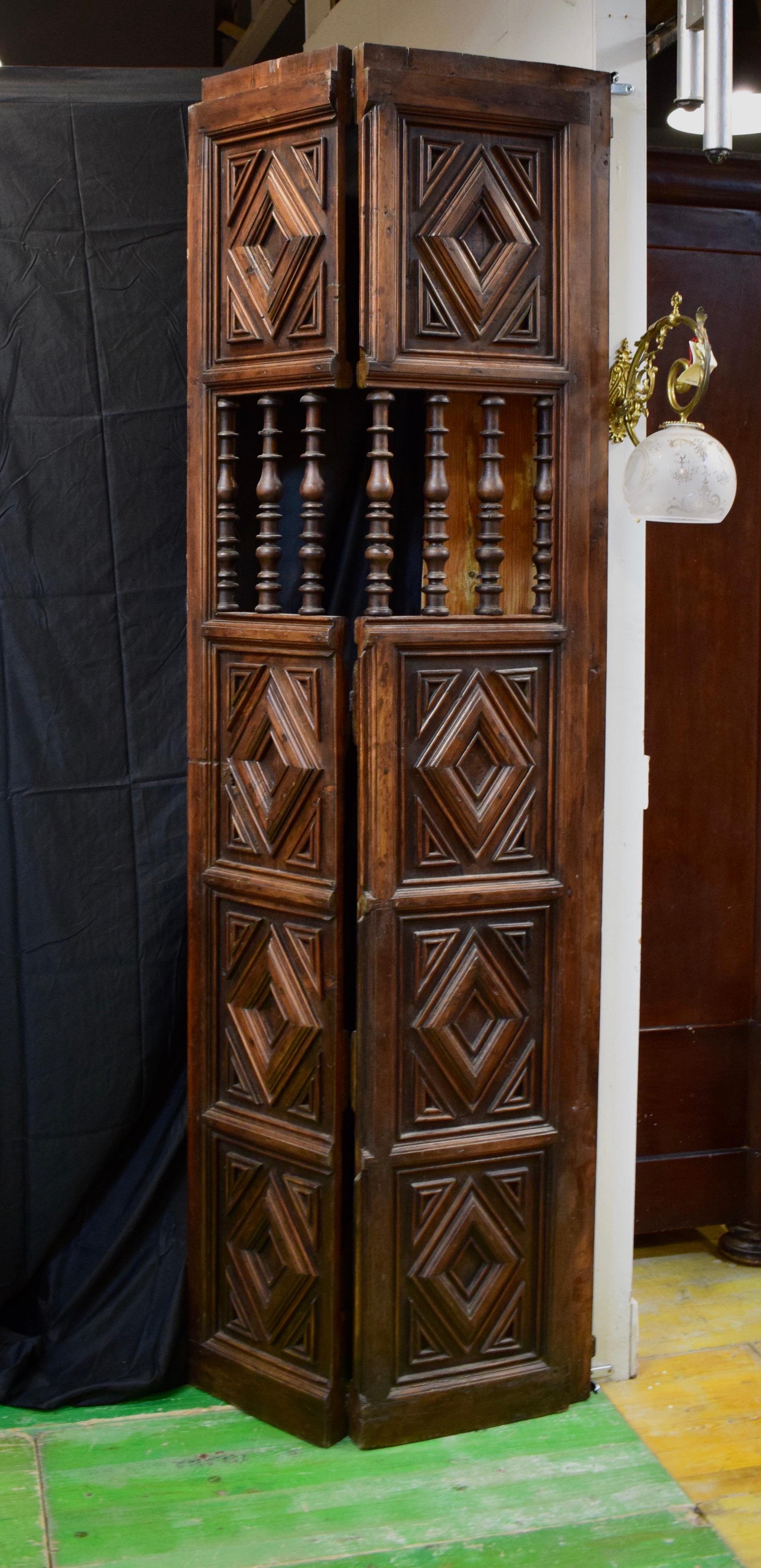 A pair of Spanish Colonial mesquite solid wood doors from the 19th century. The doors still retain their original locks and hinges. They are all functional. Each door has five panels, four recessed panels have a diamond pattern carved into the wood,