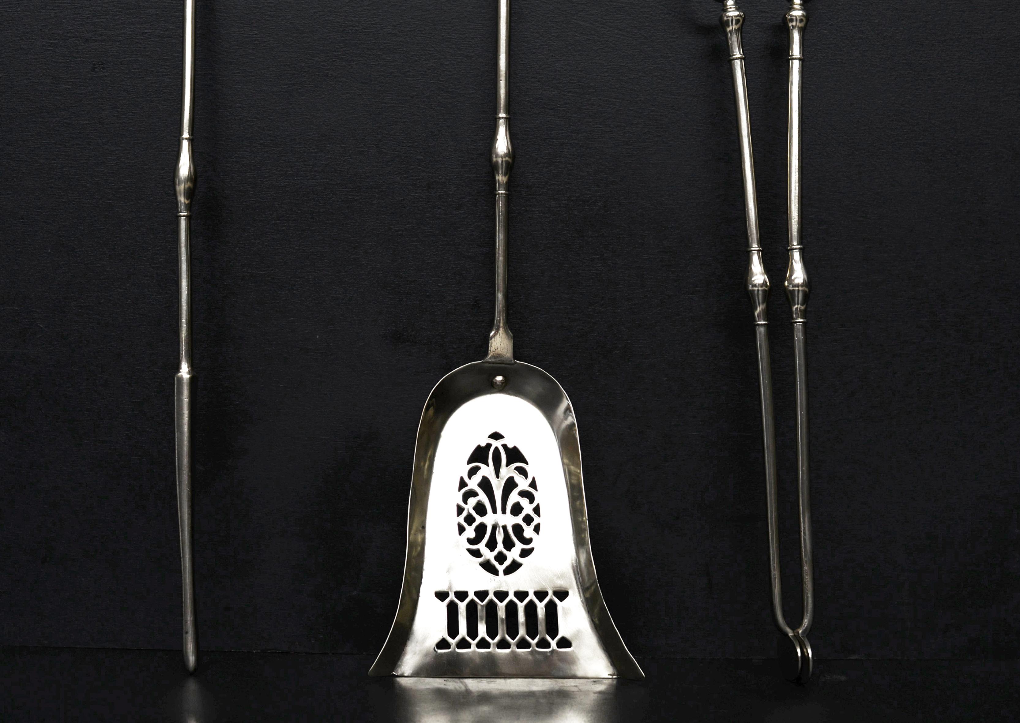 A set of steel firetools in the Georgian manner. The urn handles with swelled shafts below. Pierced pan to shovel. English, 19th century.

Length: 700 mm 27 ½