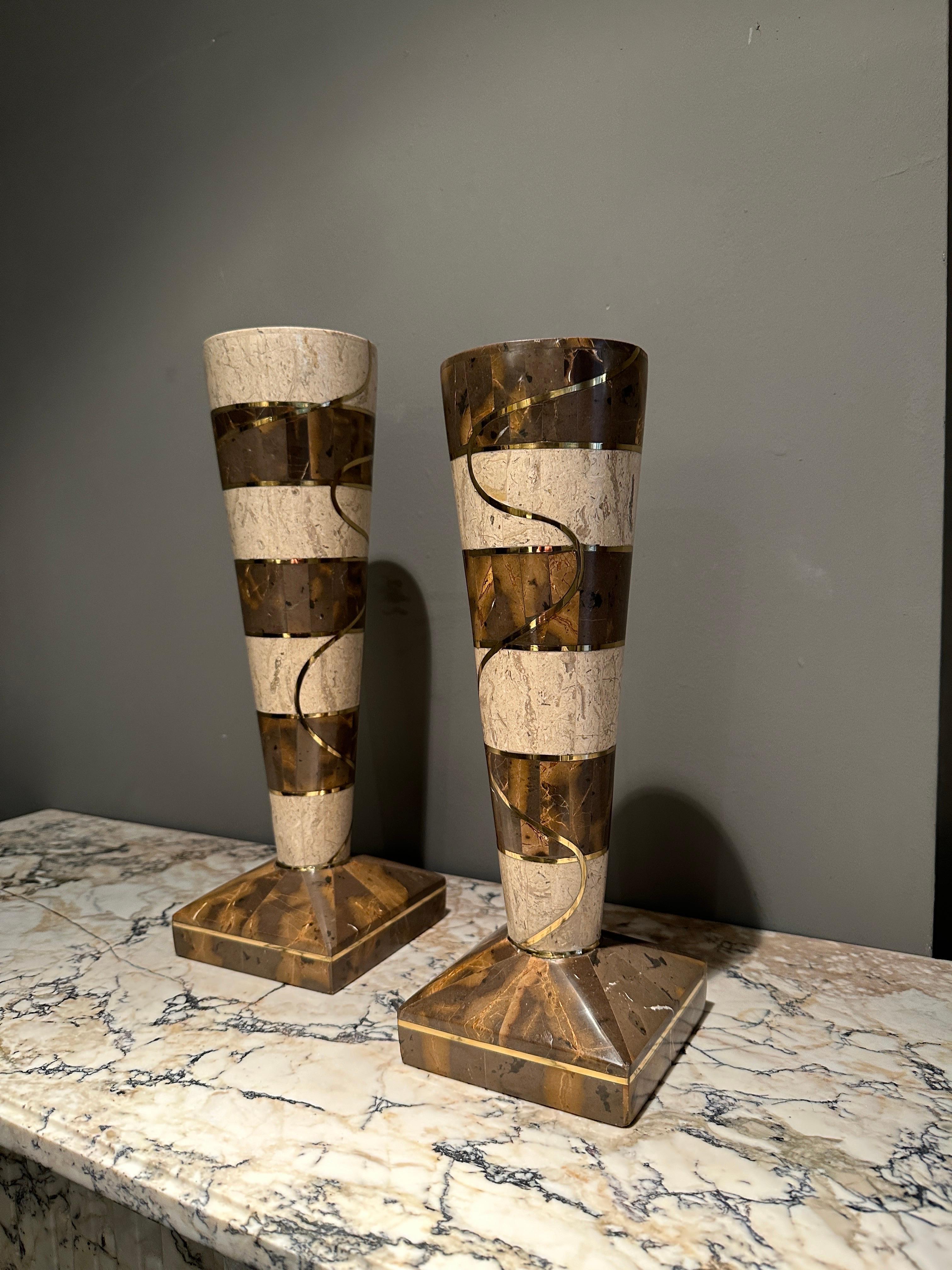 A pair of tea candle holders in tessellated marble and brass inlay. Supported on rectangle bases the stems with segmented marble uprights with stylised brass inlay. By Maitland Smith USA Circa 1980 