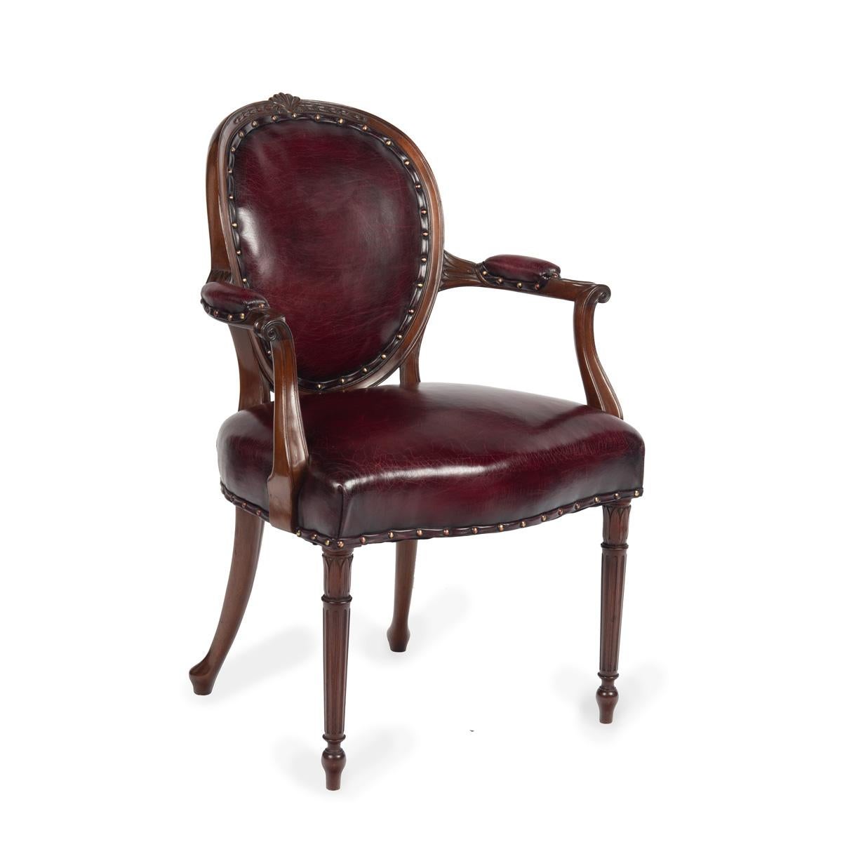 Un set di dieci sedie da pranzo vittoriane in mogano nello stile di Hepplewhite, composto da due intagliatori e otto sedie laterali; ogni intagliatore ha uno schienale arrotondato e ampi braccioli a doppia voluta, la seduta sagomata sostenuta da