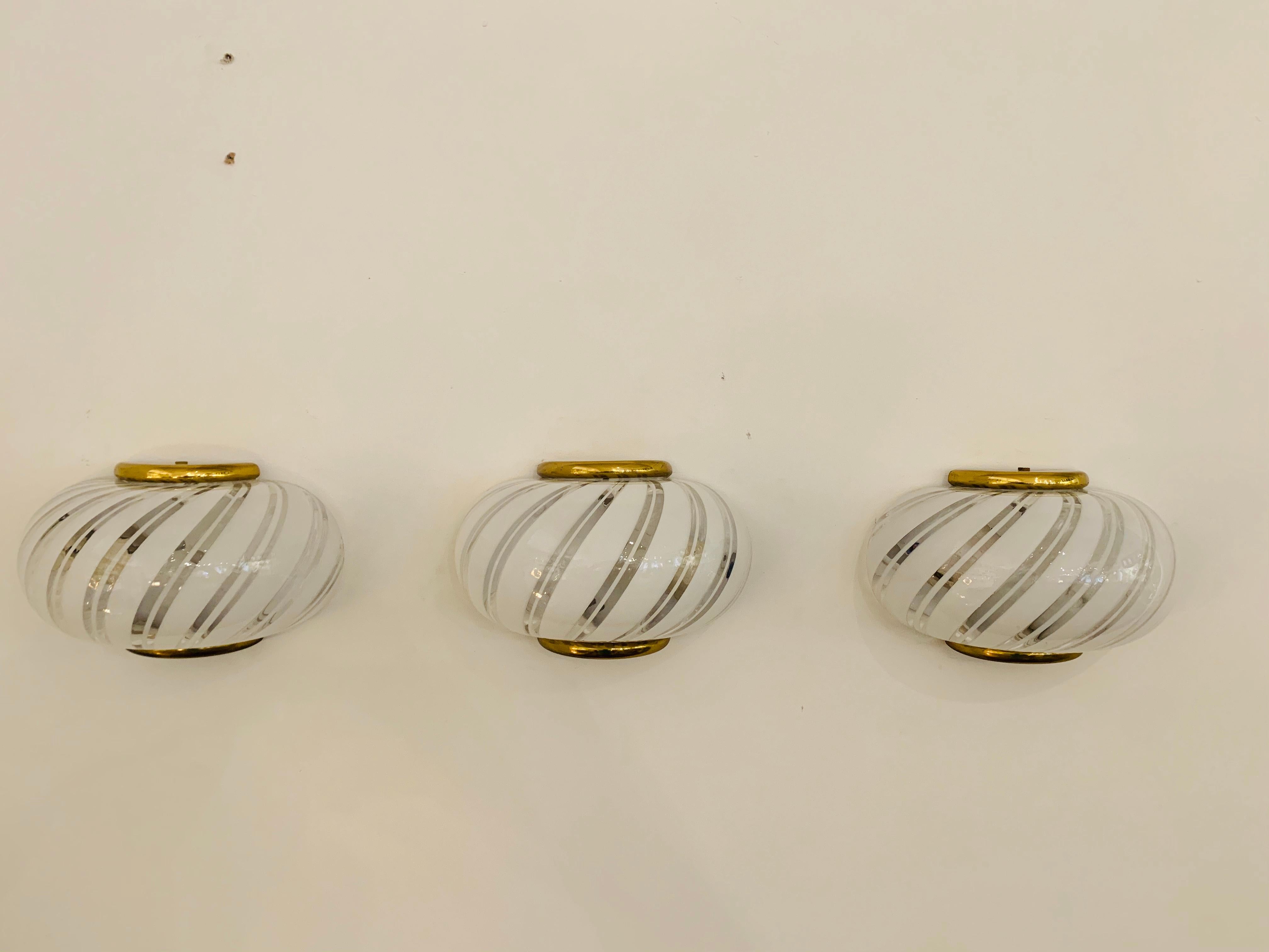 A great set of three striped white and cheese Murano glass sconces with brass holders by the Italian lighting maker, Fabbian. Rewired.Listing is for a set of three.