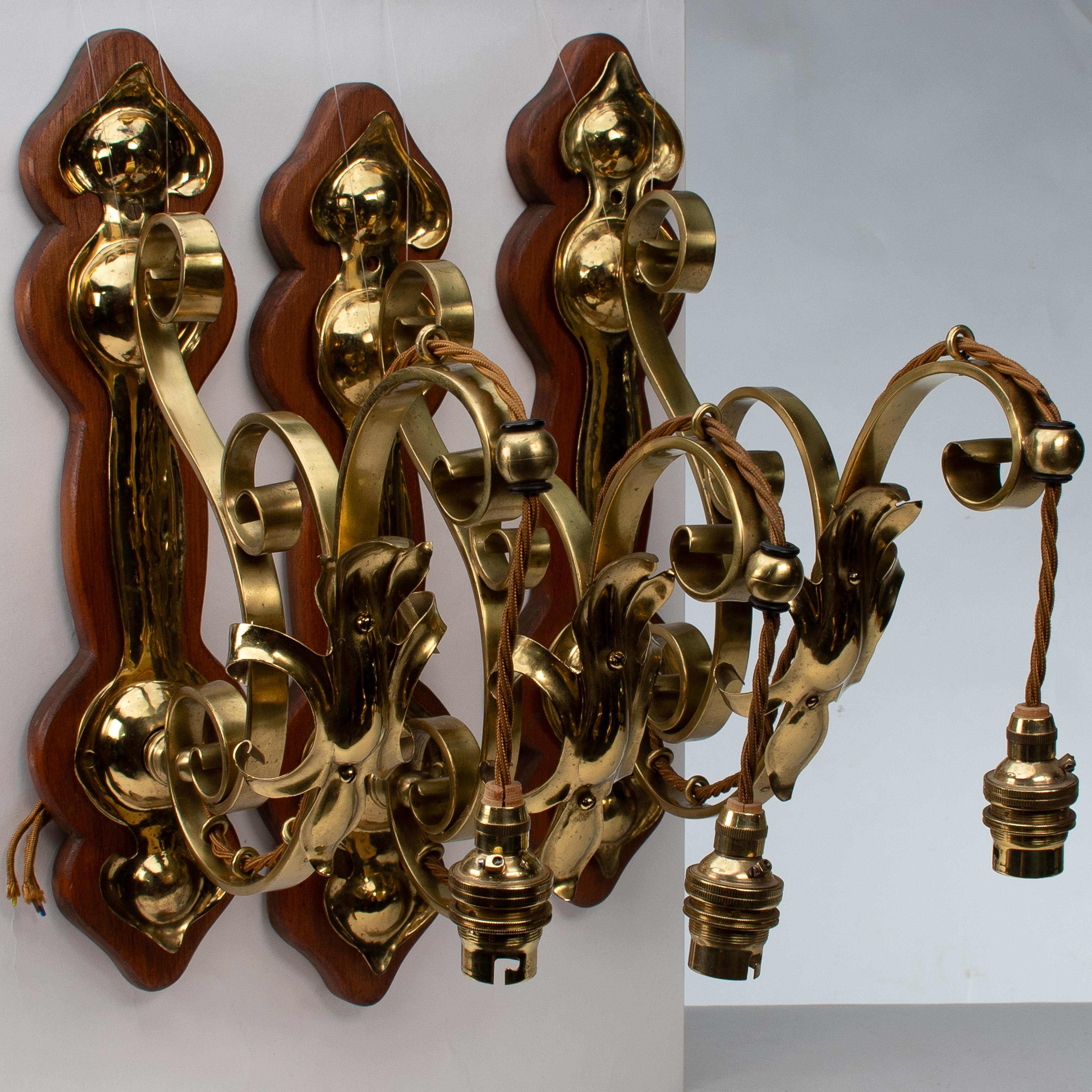 Un set di tre lampade da parete in ottone di stile Arts and Crafts con placche in legno di noce in vendita 14
