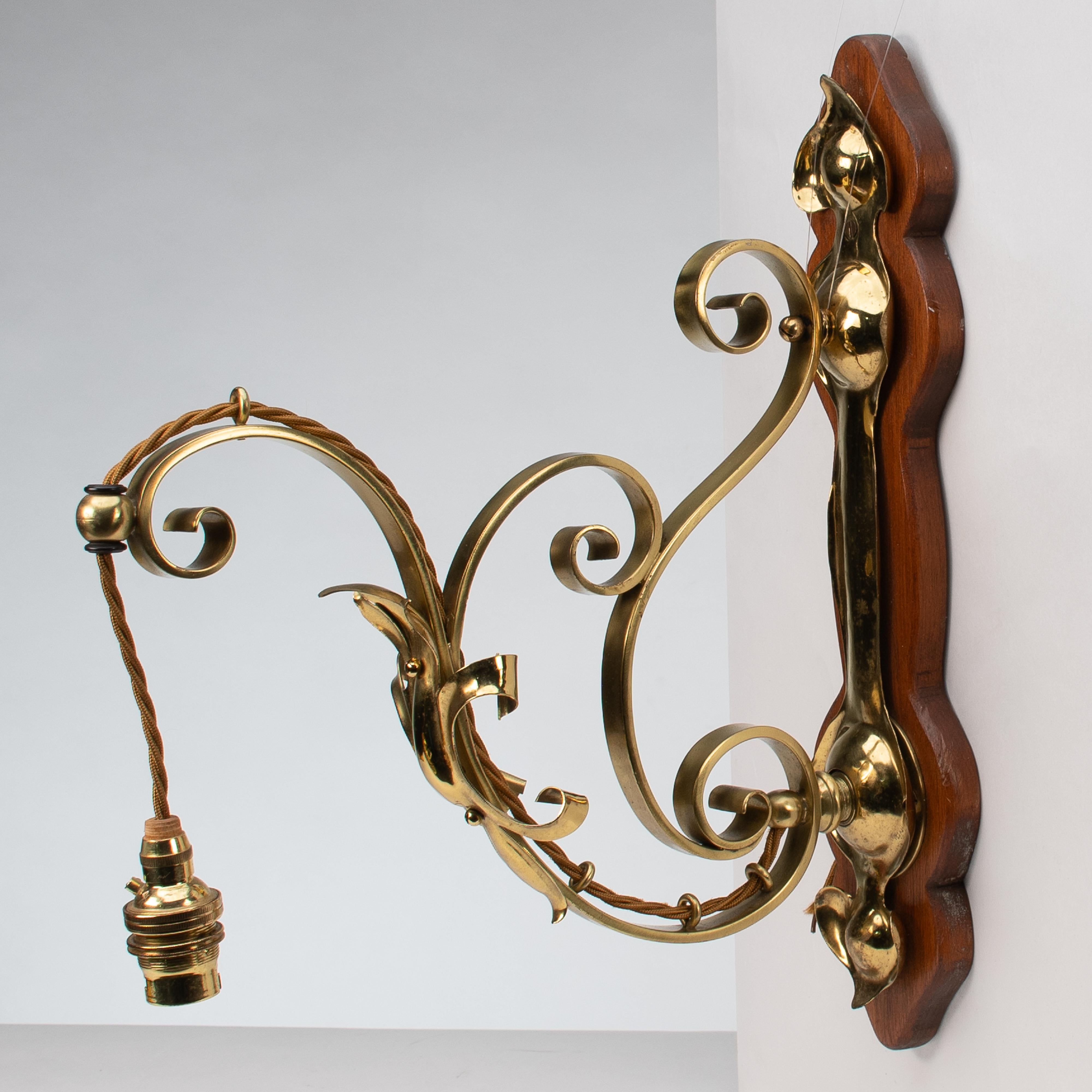 Inglese Un set di tre lampade da parete in ottone di stile Arts and Crafts con placche in legno di noce in vendita
