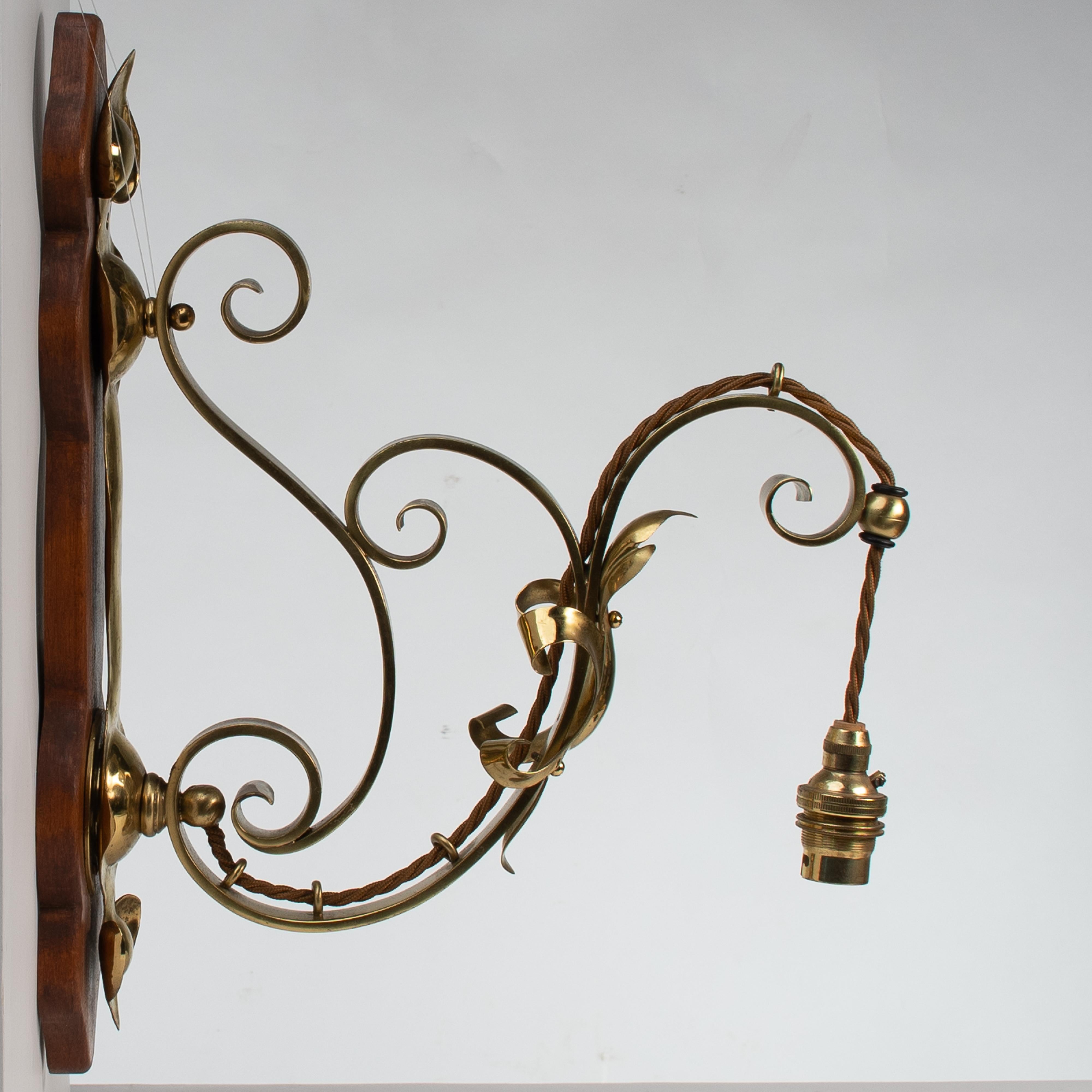 Inizio XX secolo Un set di tre lampade da parete in ottone di stile Arts and Crafts con placche in legno di noce in vendita