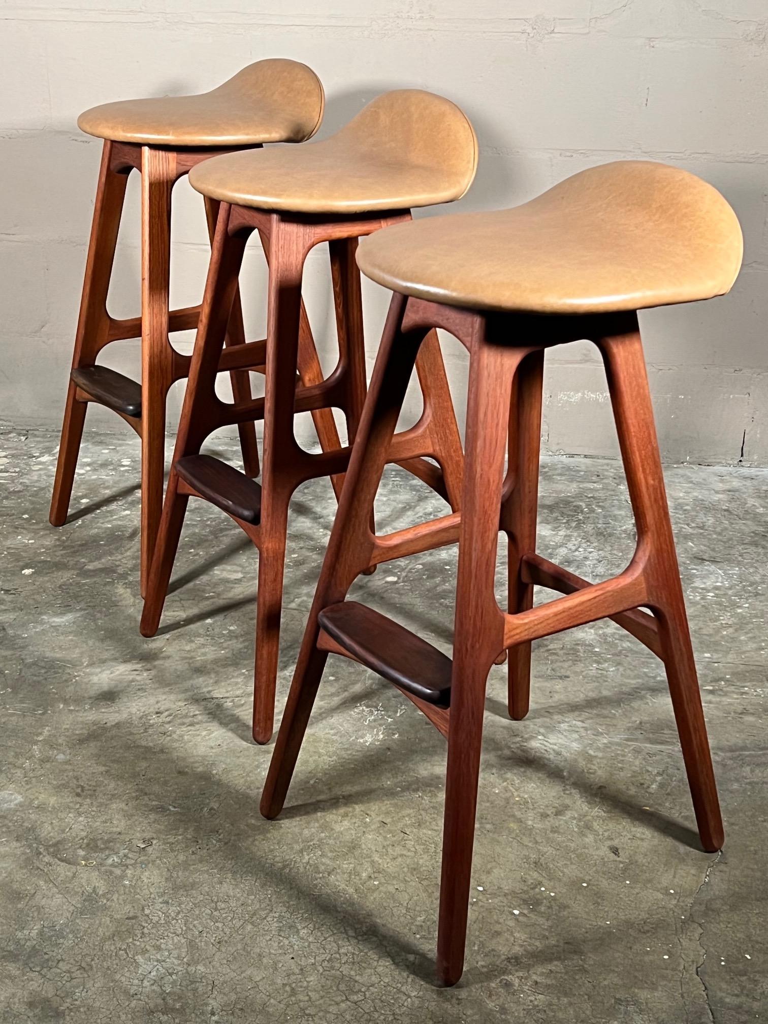 Erik Buck(Buch) Bar Stools Model OD-61 Produced by Oddense Møbelfabrik in Denmark. This is a set of three, made of teak/rosewood. Restored and reupholstered in brown leather. Total height is 32.5