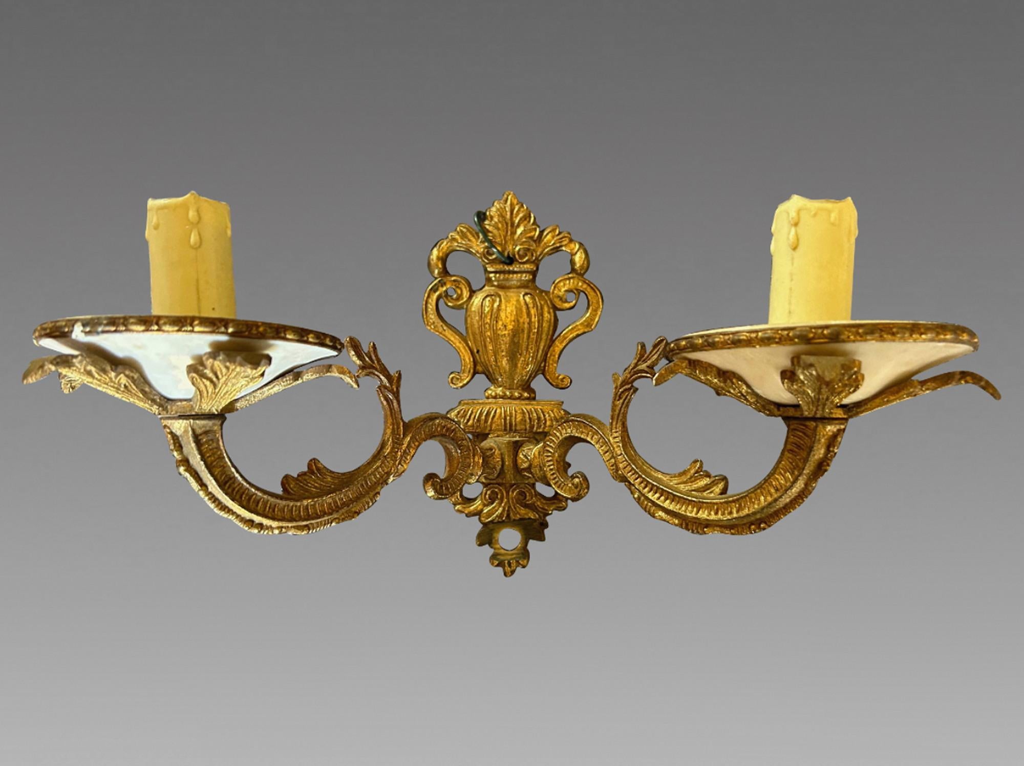 A set of three mid-C20th European two branch wall lights in gilded metal with ceramic drip trays. Fully rewired and PAT tested to modern standards. 