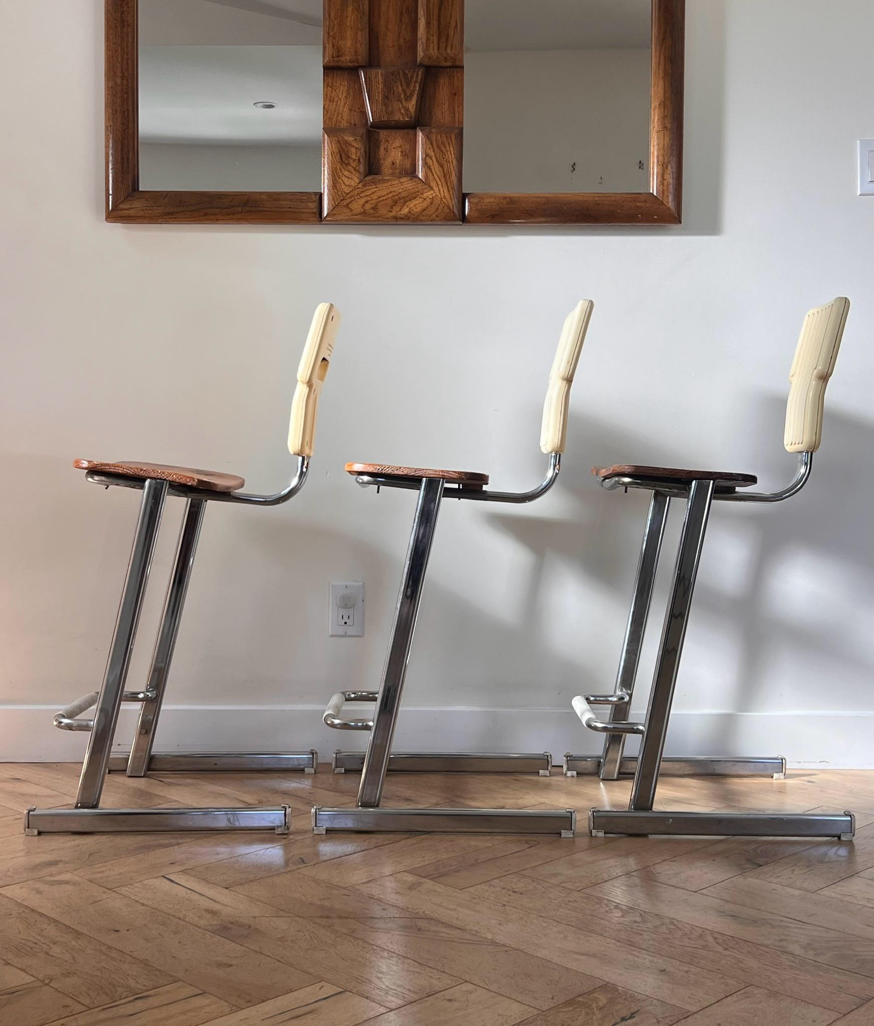 A set of three rare postmodern “Condor” bar or counter stools designed by Andries And Hiroko Van Onck for Magis, circa 1980. These iterations of this particular design are incredibly unique - showcasing wood seats and a back rest in heavy cream. The