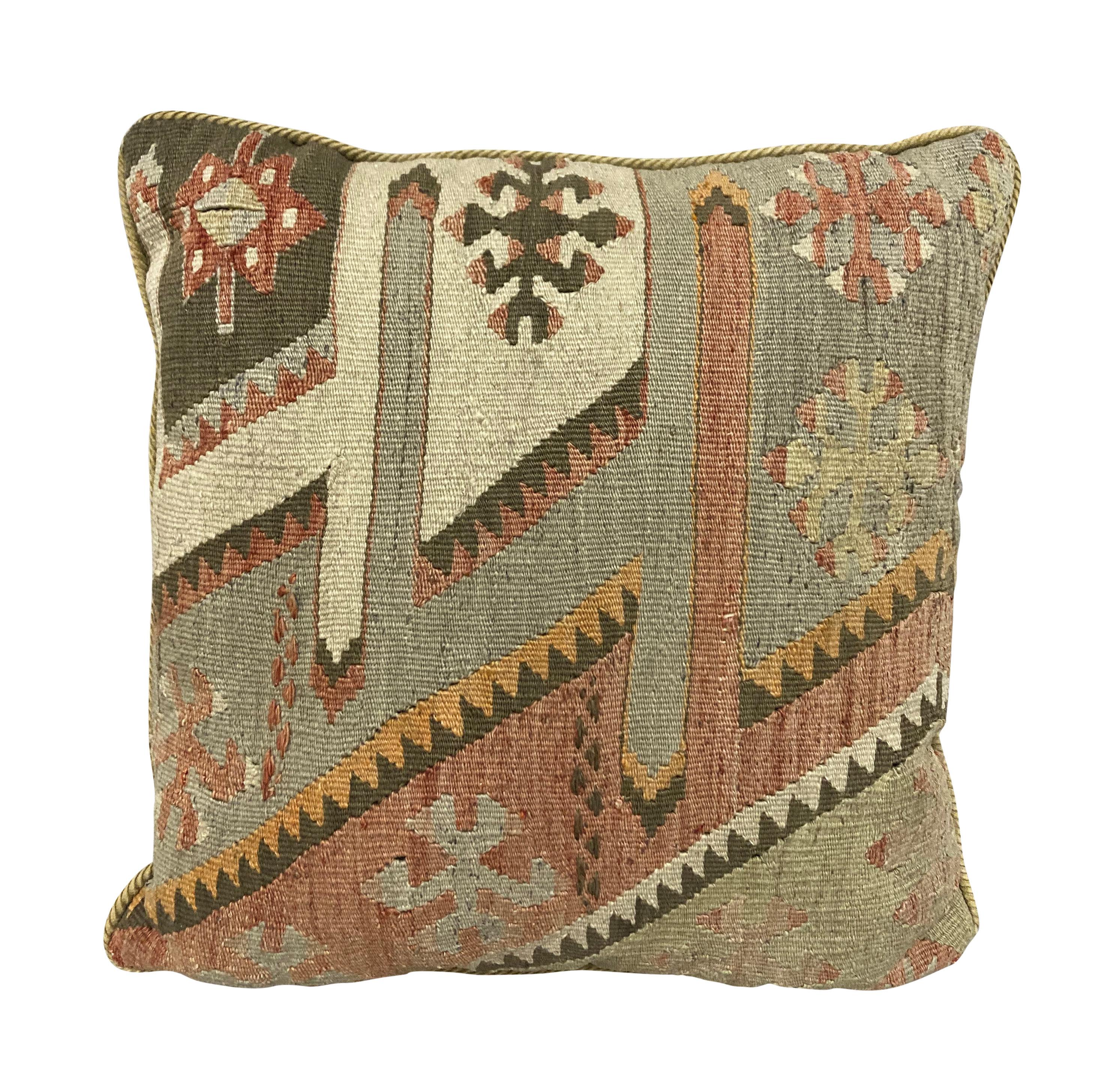 A set of three cushions, fashioned out of XIX Century kilims, which are naturally faded. With feather pads and corduroy backs.