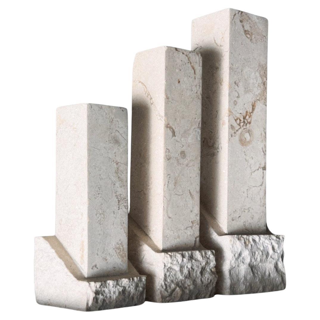 A set of three neoclassical postmodern “Ruins” stone candleholders, late 20th c