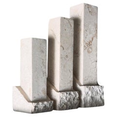 A set of three neoclassical postmodern “Ruins” stone candleholders, late 20th c