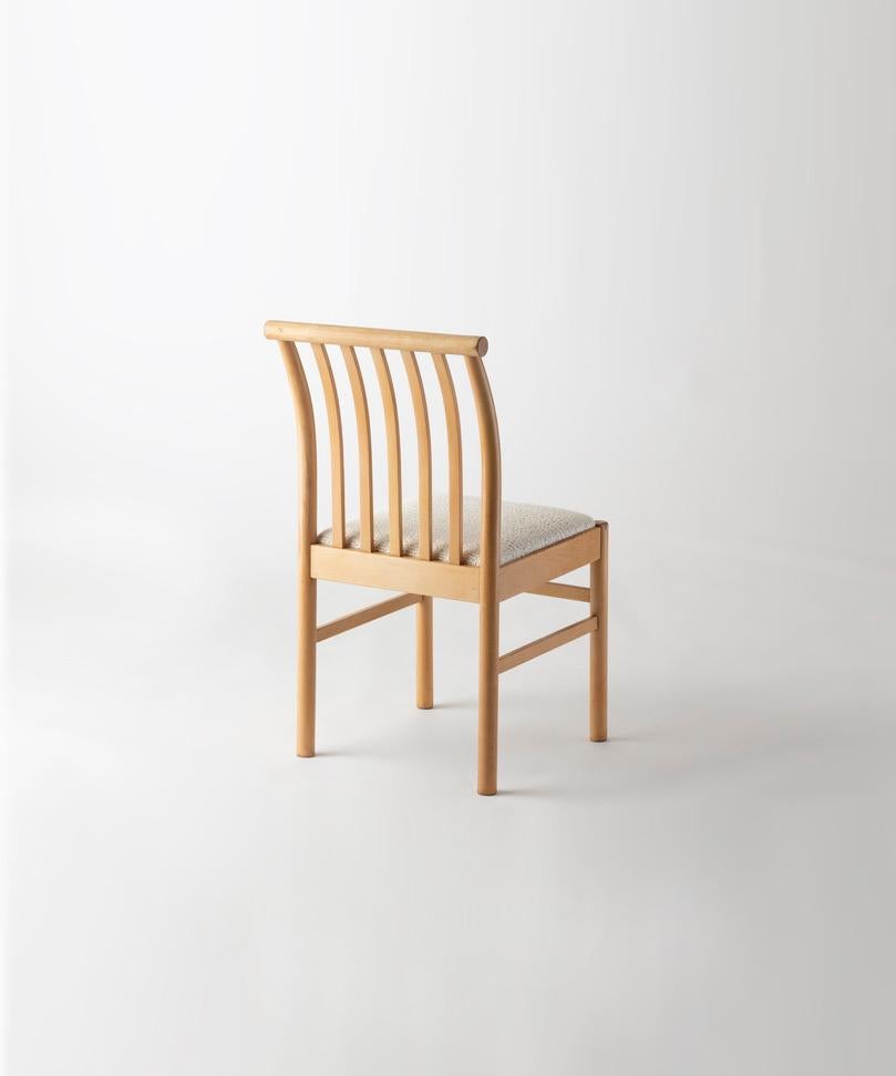 A set of twelve chairs by the Japanese designer Isamu Kenmochi, in maple & Pierre Frey fabric, manufactured by Akita Mokko, Japan, circa 1960.