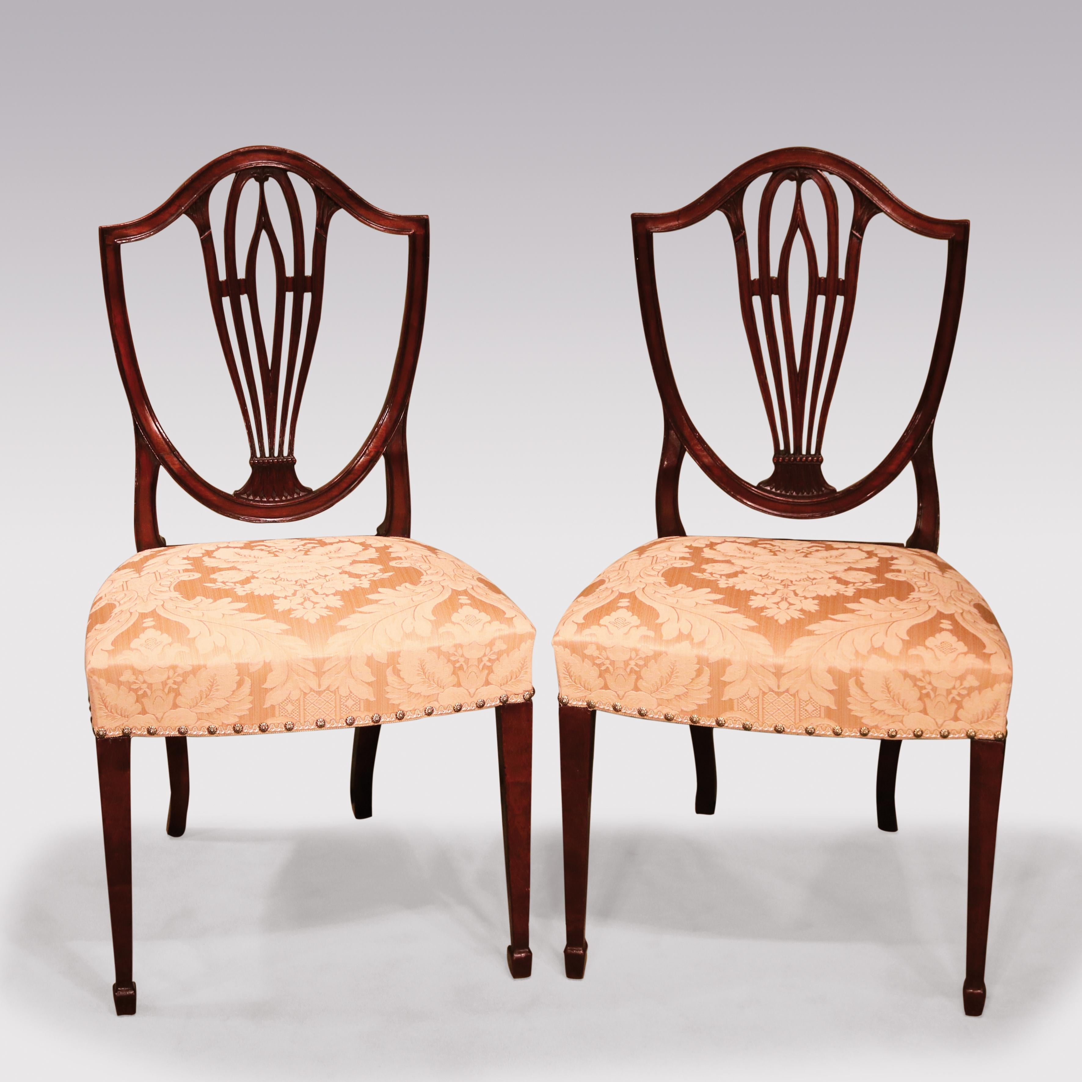 A Set of 10 single & 2 arm late 18th Century Hepplewhite period mahogany Dining chairs, having shield-shaped backs containing well-carved splats supported on spade toes. ( One side chair of later date).