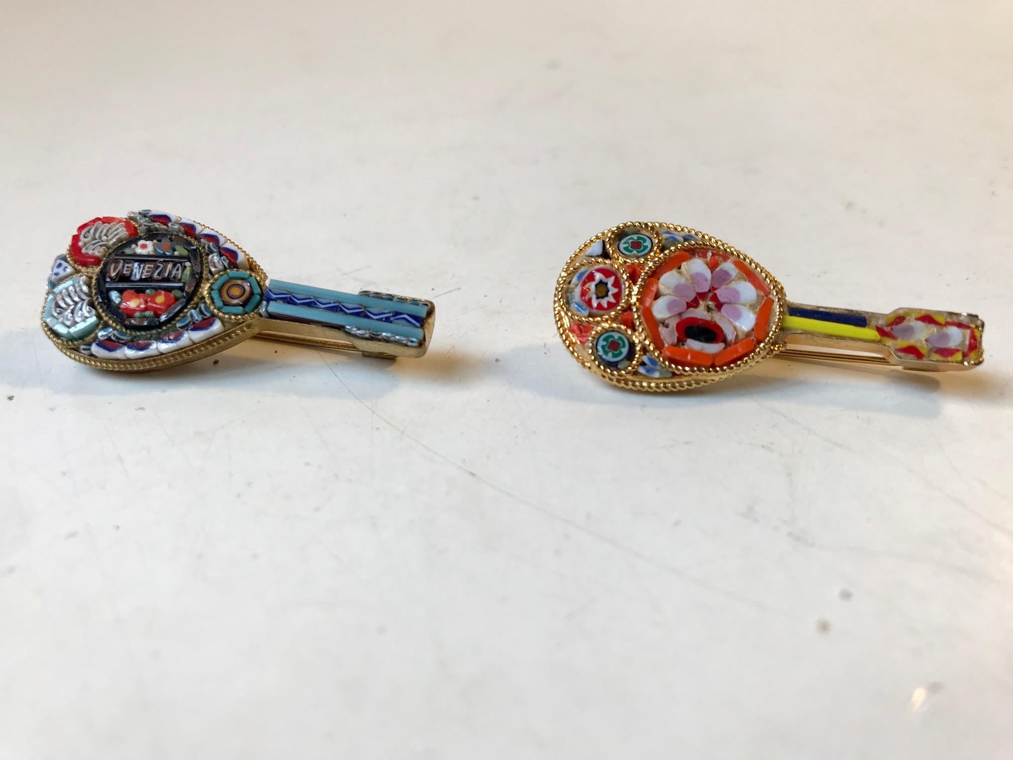 A set of lute/guitar brooches made in Venice Italy during the 1960s or 1970s. The micro mosaic consists of tiny pieces of colored glass. Set into gilt brass frames in the shape of lutes/guitars. The price is for both.
