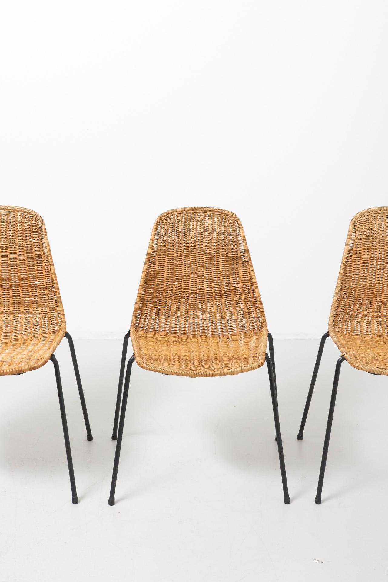 A set of 4 rattan chairs designed in 1951 for the Italian Restaurant “The Basket”, by the Swiss designer Gian Franco Legler. These chairs have a black steel frame with a black rubber coating on the legs. The chairs are stackable. The chair received