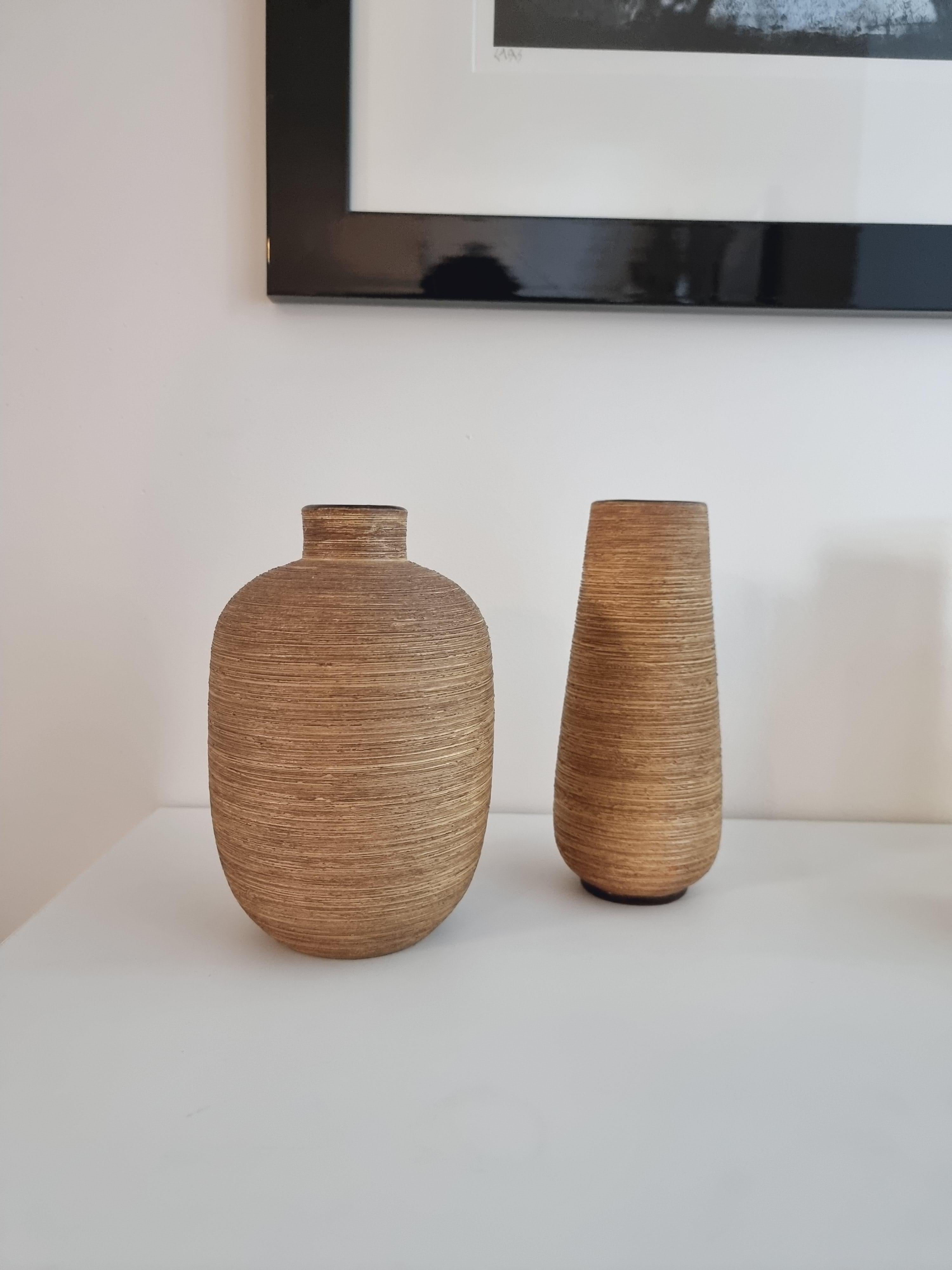 Un ensemble de deux vases, avec une structure organique chaleureuse. Signé Ekeby, conçu par Greta Runeborg, Suède, milieu des années 1900.

Petits signes d'usure, une minime/petite bosse/perte de couleur sur un vase.

Greta Runeborg-Tell