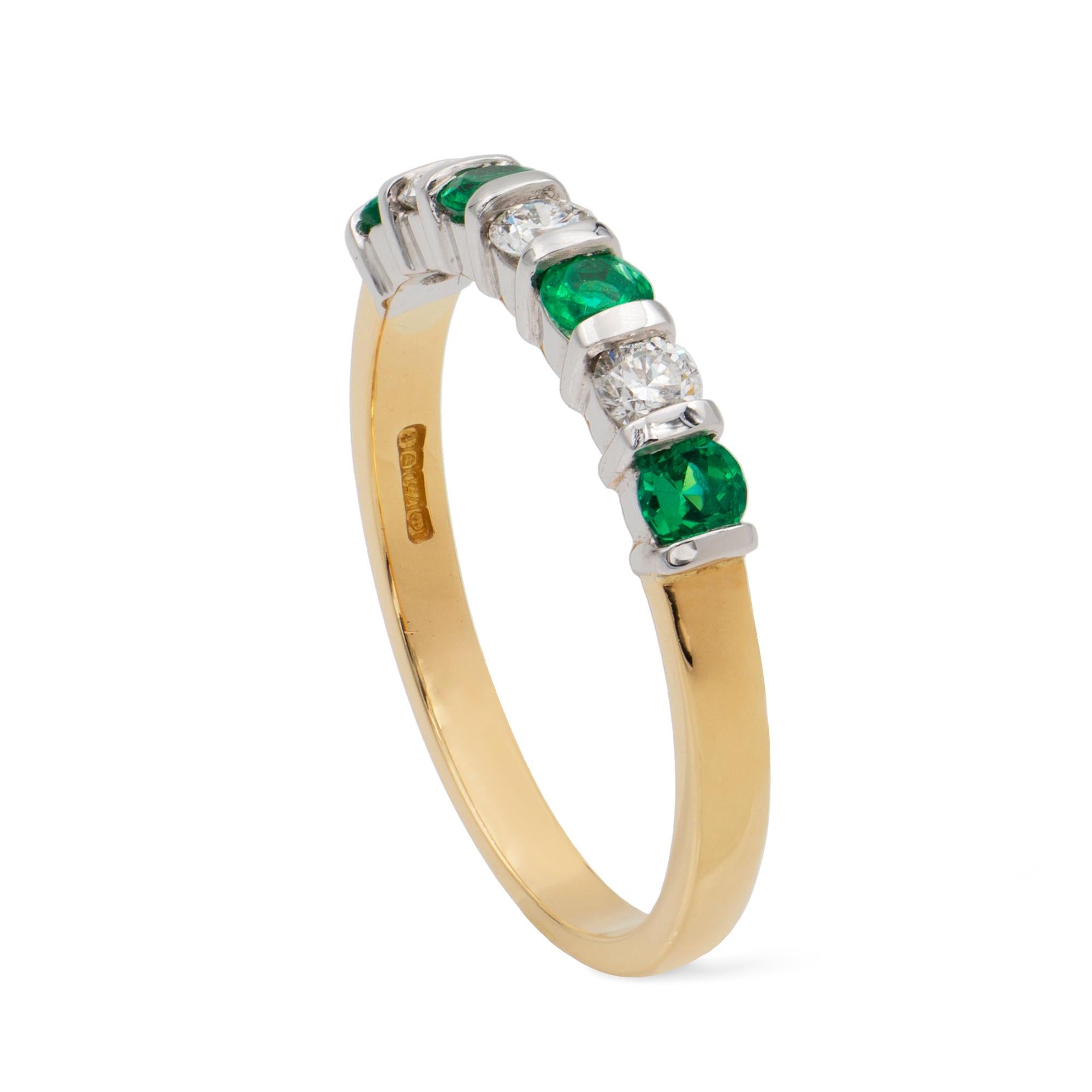 A seven stone diamond and emerald ring, three round brilliant cut diamonds weighing a total of 0.22ct and four round faceted emeralds weighing a total of 0.27ct, in white bar setting, on yellow shank, hallmarked 18 carat gold, London 2018, measuring
