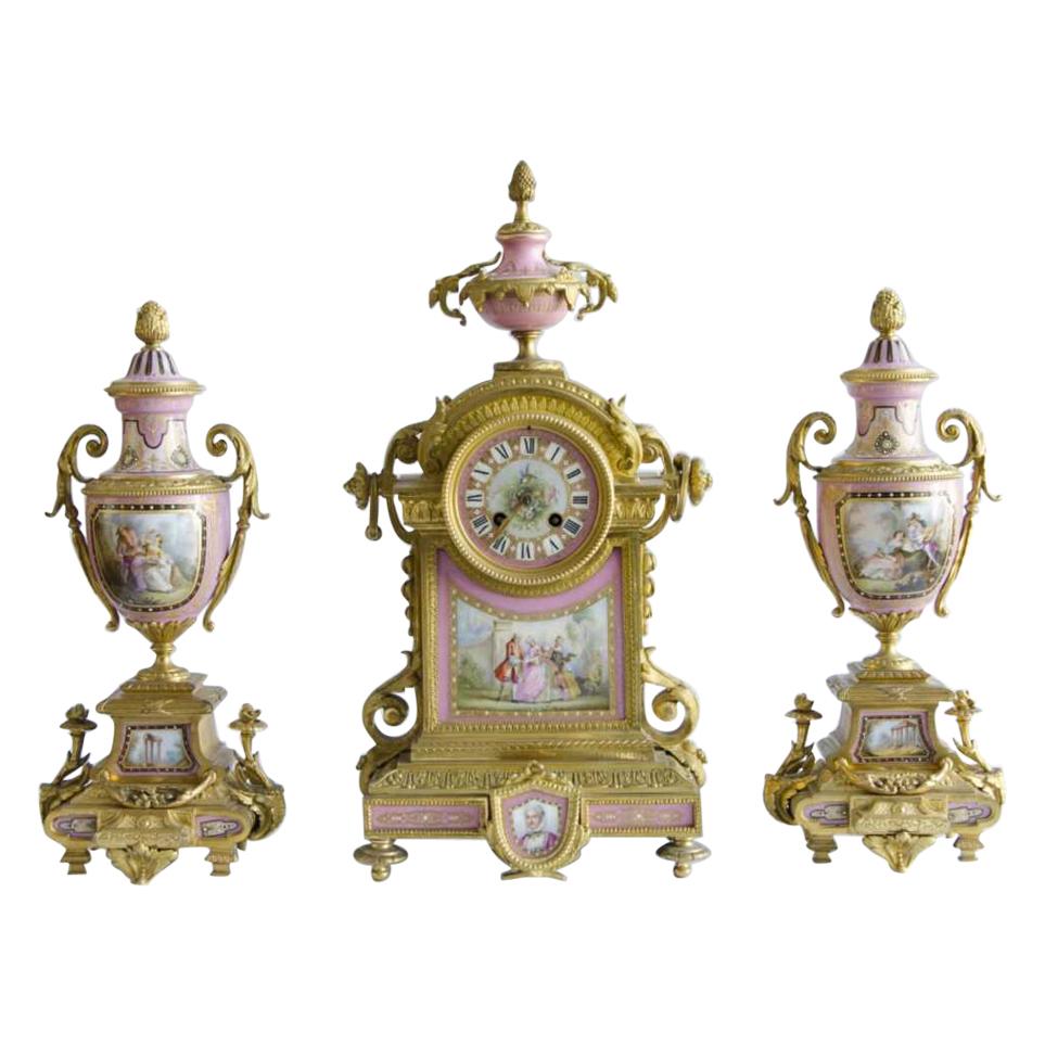 A Sevres style Ormolu mounted jewelwd procelain 
Rose pomedur clock garniture 19th century
50 cm x 24 cm the clock 

15 cm x 40 cm flanked 
with pastoral scens ( teserves ).