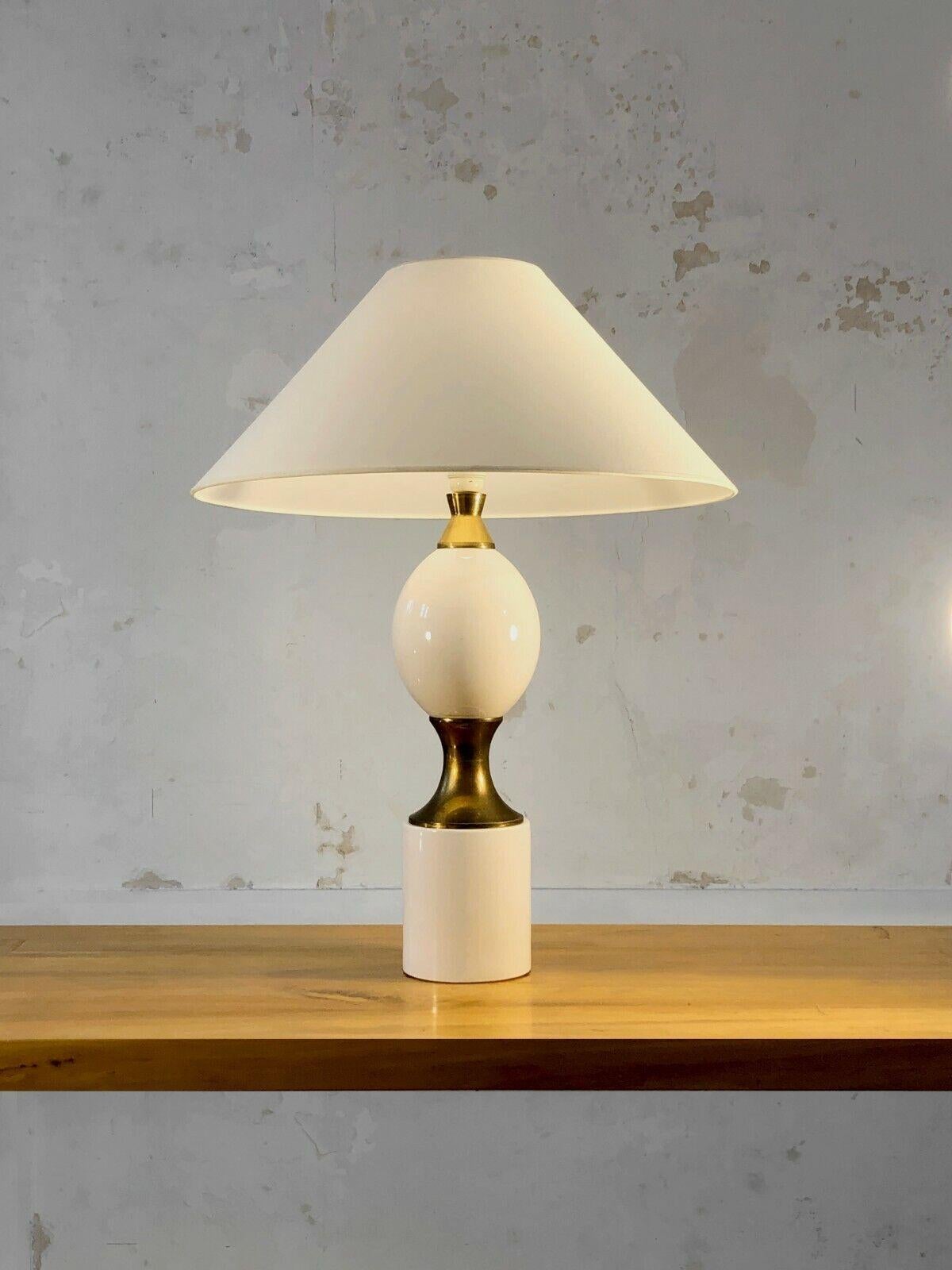 An elegant, luxurious and very large table lamp, Art-Deco, Post-Modernist, Neo-Classical, Shabby-Chic, Cylindrical base and ovoid body in thick white enameled ceramic, gilded bronze finishes, to be attributed, France 1970.

A formal similarity with
