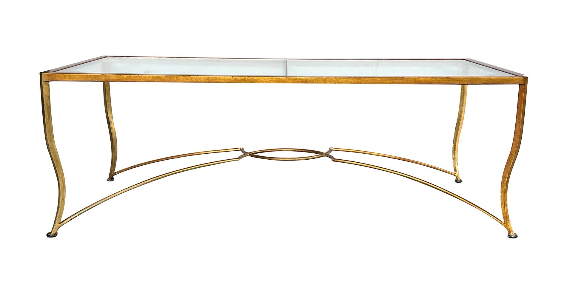 the rectangular inset glass top within a gilt-iron frame with canted corners all raised on graceful cabriole supports; joined by an arching and interlacing stretcher; new glass; overall rubbing and wear to gilding; good sturdy frame