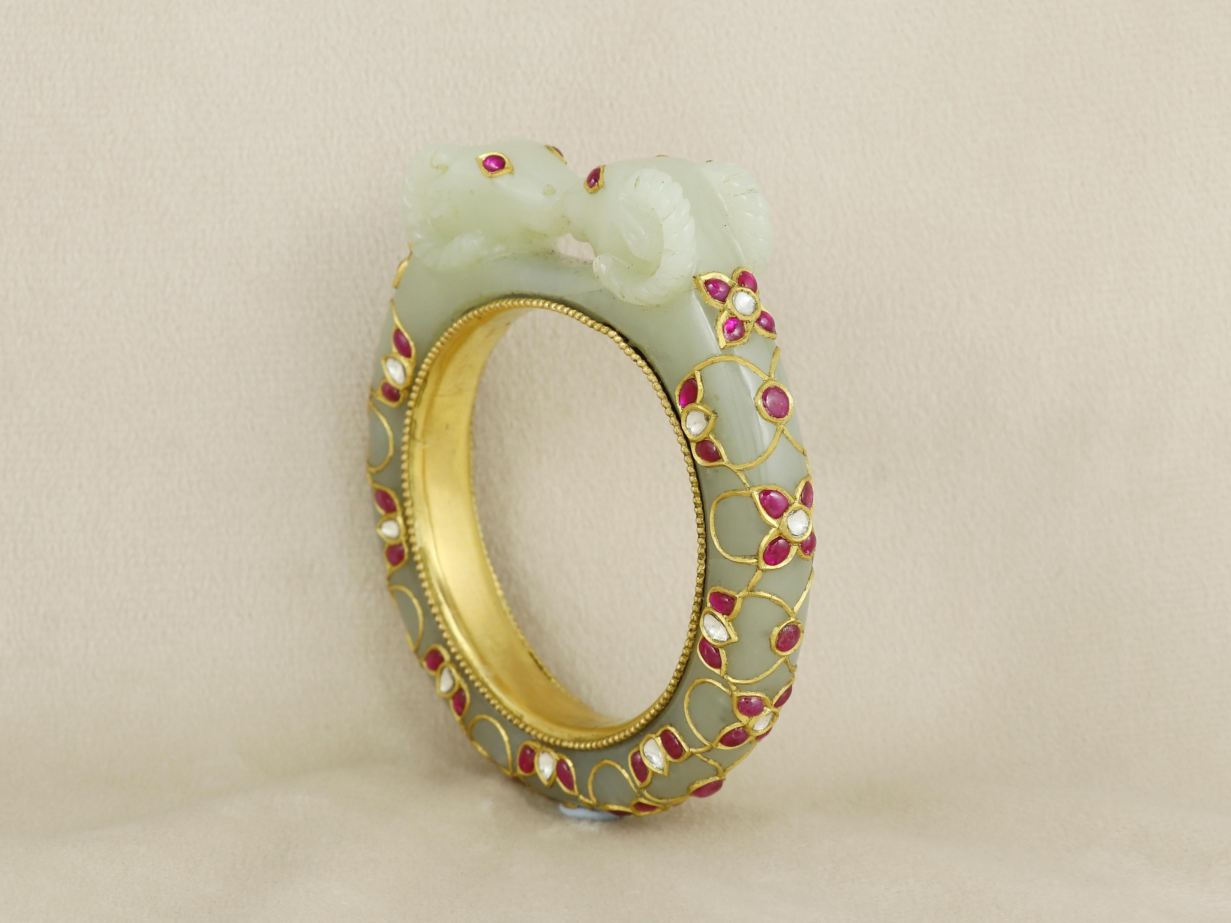Esta llamativa pulsera de jade nefrita, rara expresión de artesanía tradicional y diseño simbólico, está magistralmente tallada en una sola pieza de jade, testimonio de la habilidad y precisión de la herencia artesanal. El brazalete presenta dos