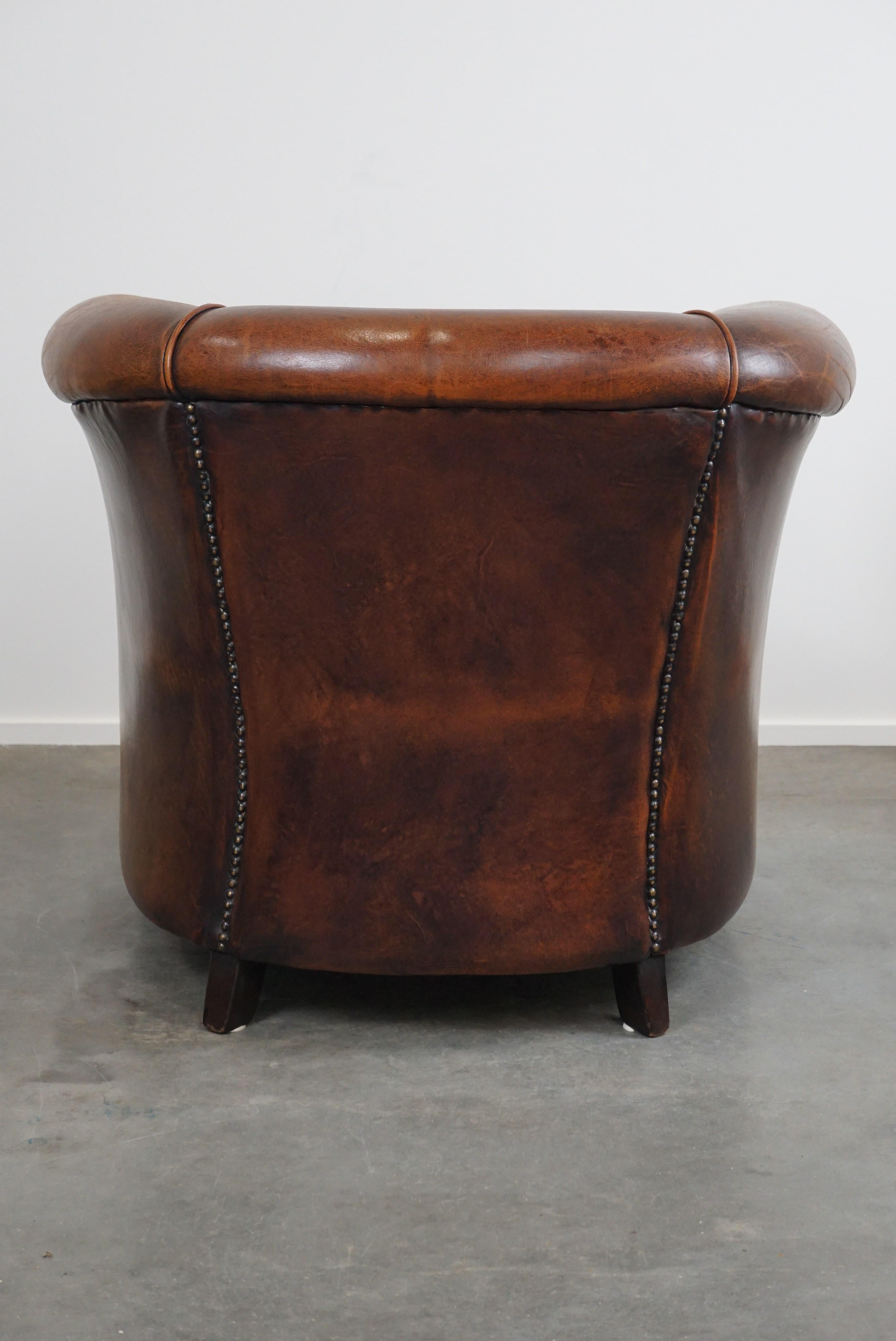 Hand-Crafted A sheep leather club armchair in good condition, modest in size. For Sale